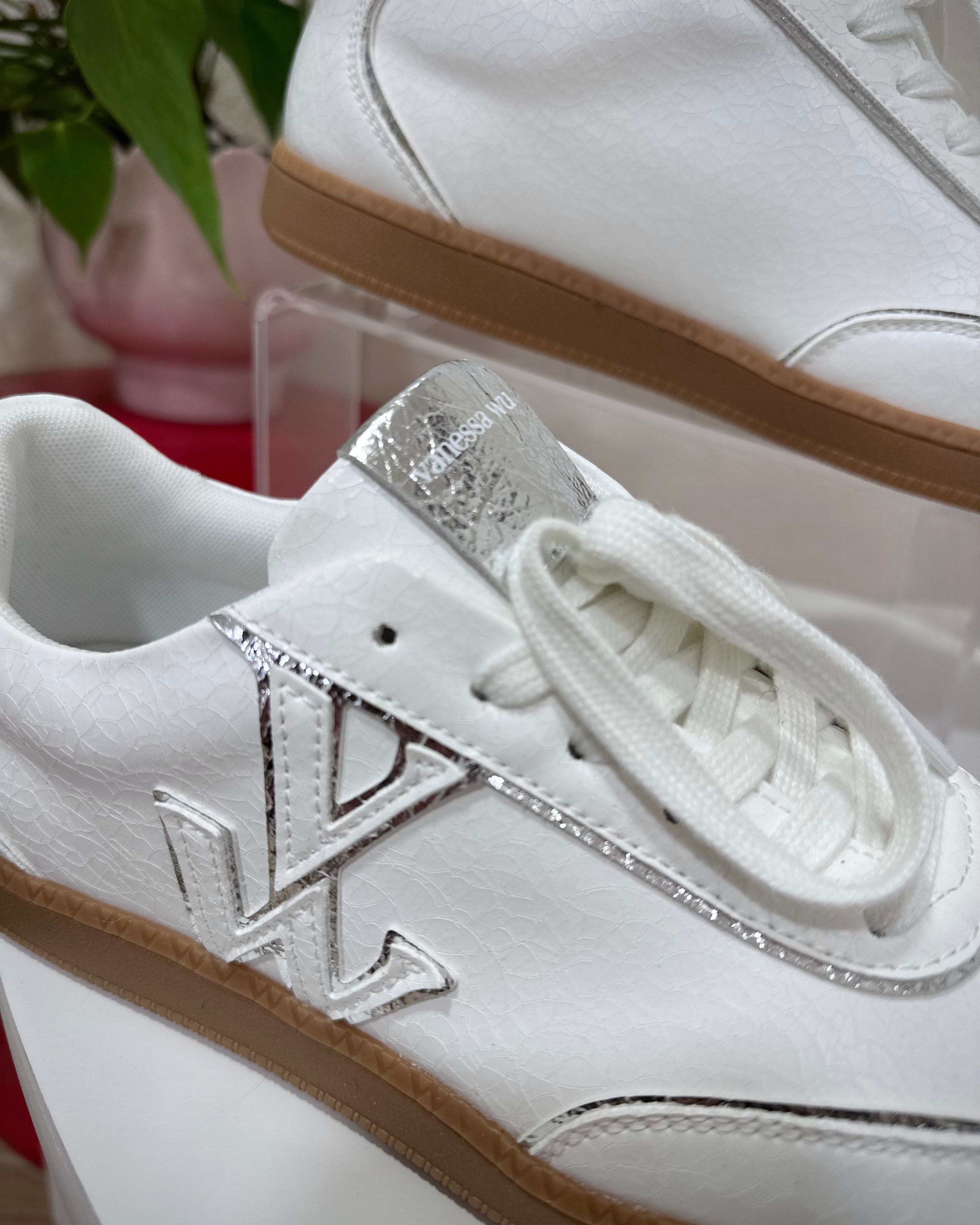 Détail du monogramme Vanessa Wu sur baskets blanches craquelées