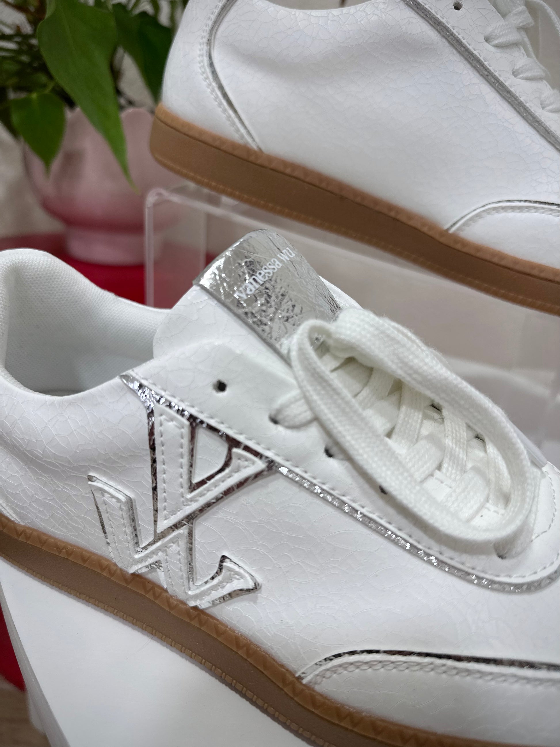 Détail du monogramme Vanessa Wu sur baskets blanches craquelées