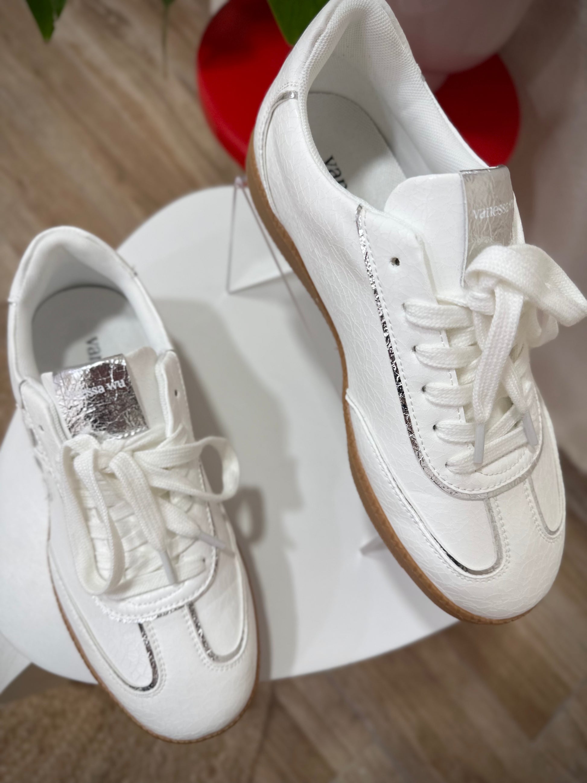 Gros plan sur les liserés argent des baskets AURA Initials Vanessa Wu