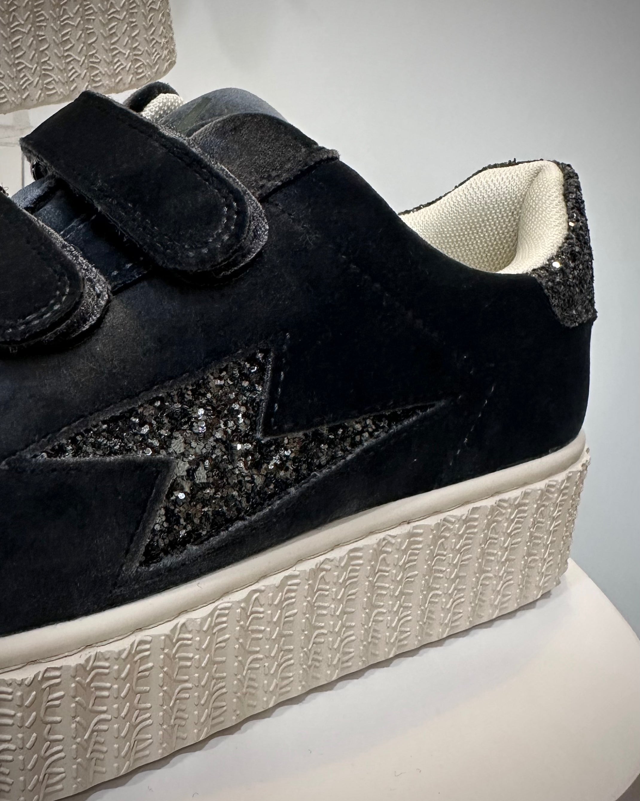 Gros plan sur la découpe éclair pailletée noir et argent des Baskets Billie