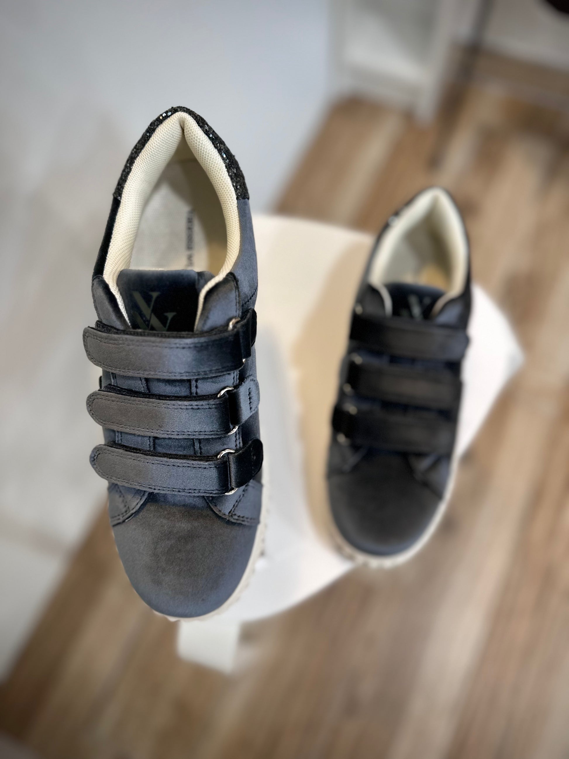 Gros plan sur l’embout rond en velours noir des sneakers