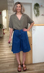 Femme portant un bermuda denim bleu coupe large 