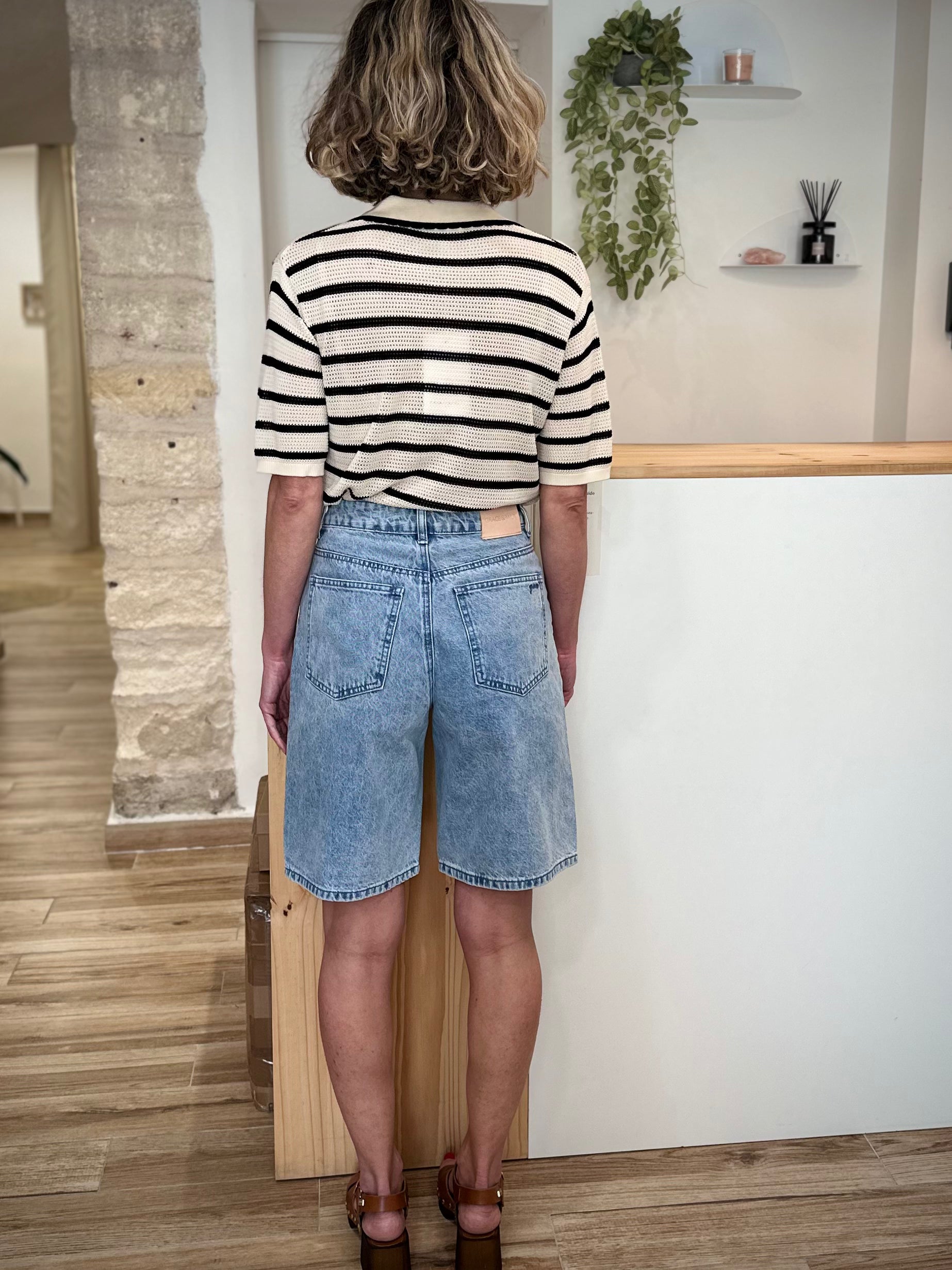Femme de dos portant un bermuda denim coupe droite été 