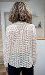 Femme de dos portant une blouse dentelle avec un pantalon noir