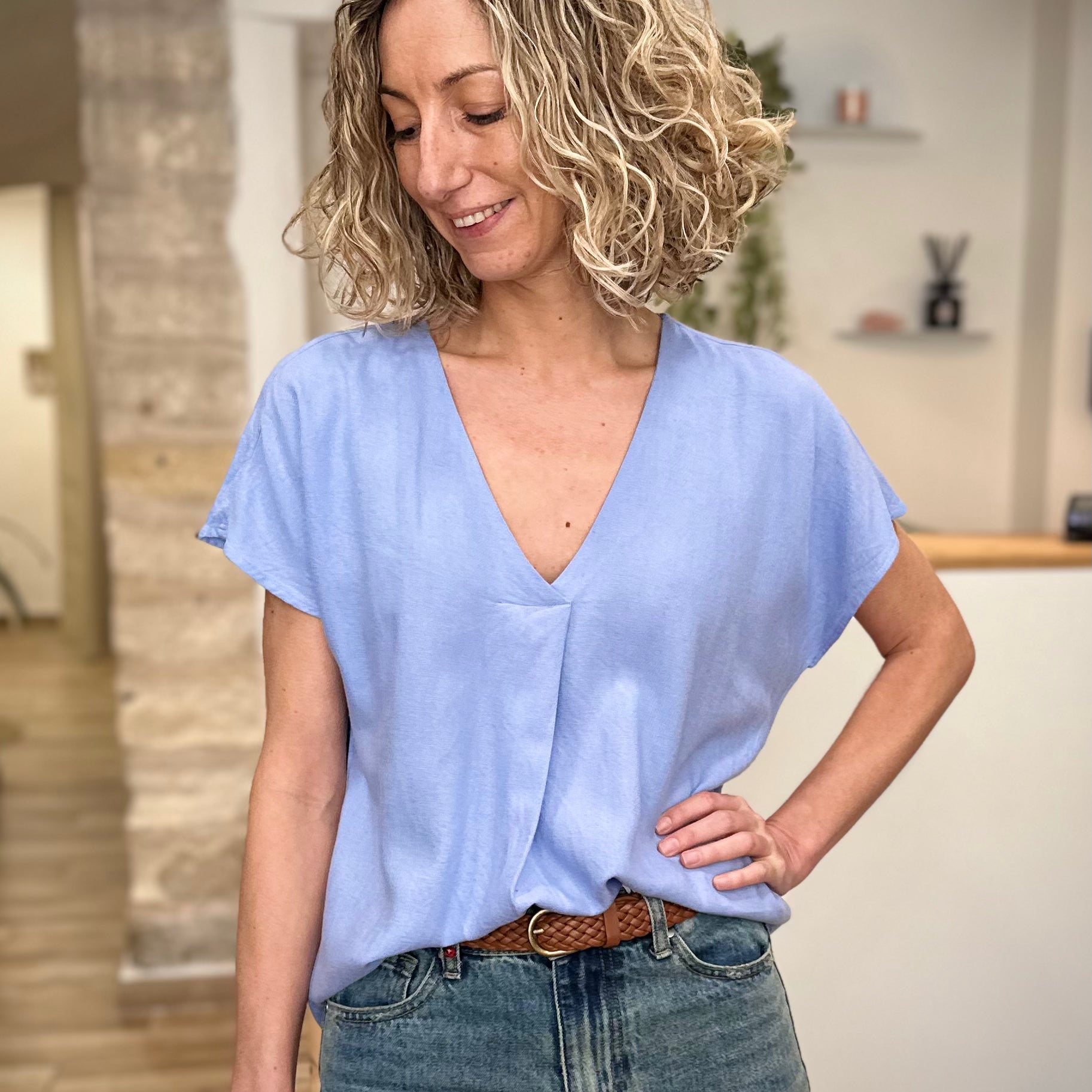 Femme portant une blouse bleu clair fluide 