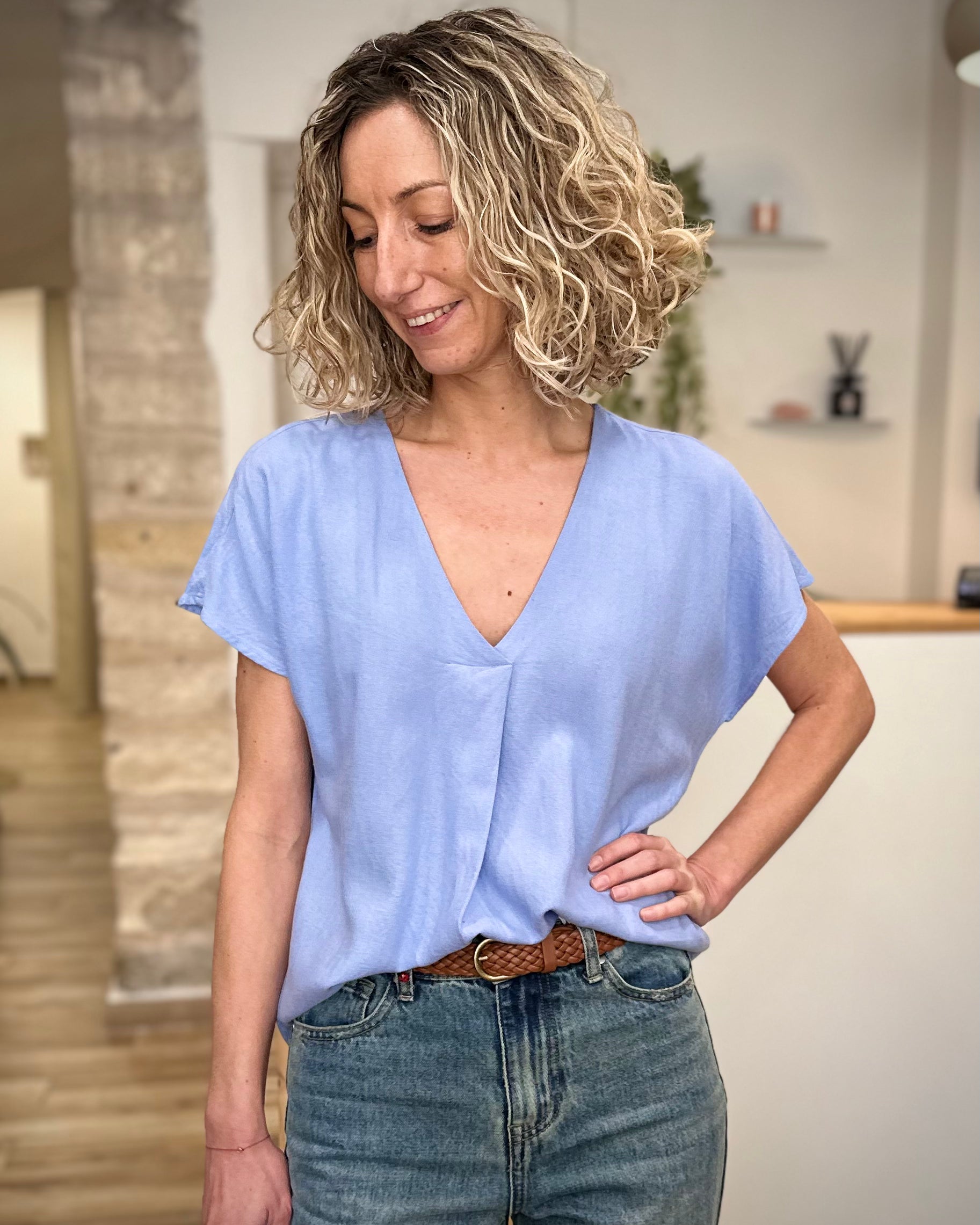 Femme portant une blouse bleu clair fluide 