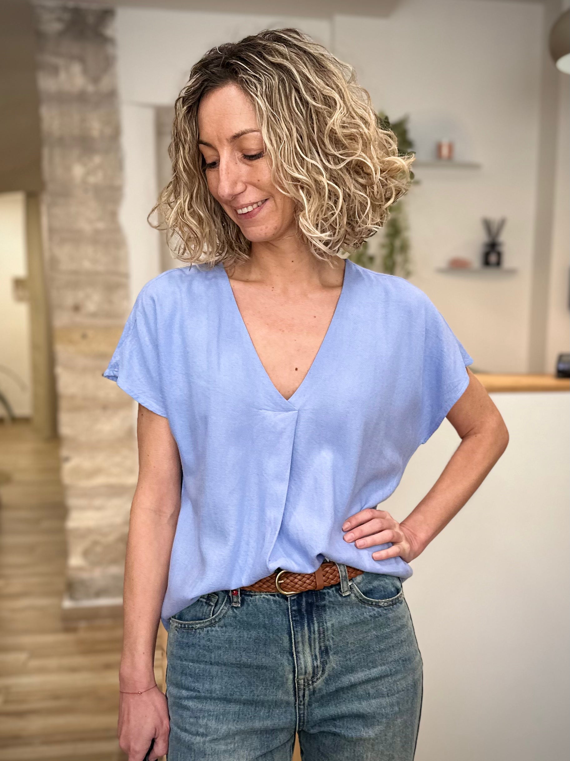 Femme portant une blouse bleu clair fluide 
