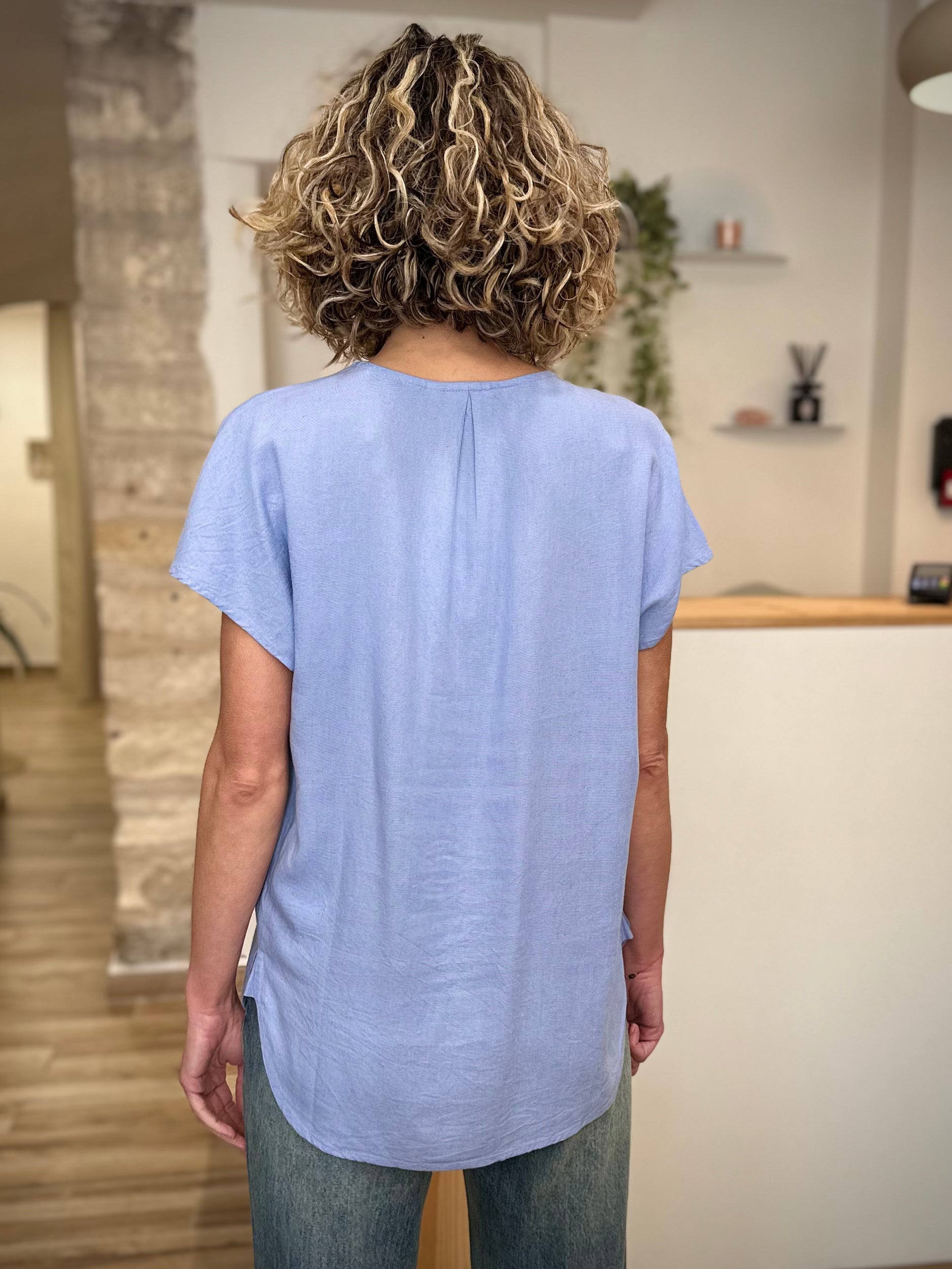 Blouse bleu clair coupe droite longueur hanches de dos