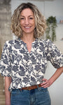 Femme portant une blouse florale écru et bleu marine coupe fluide 