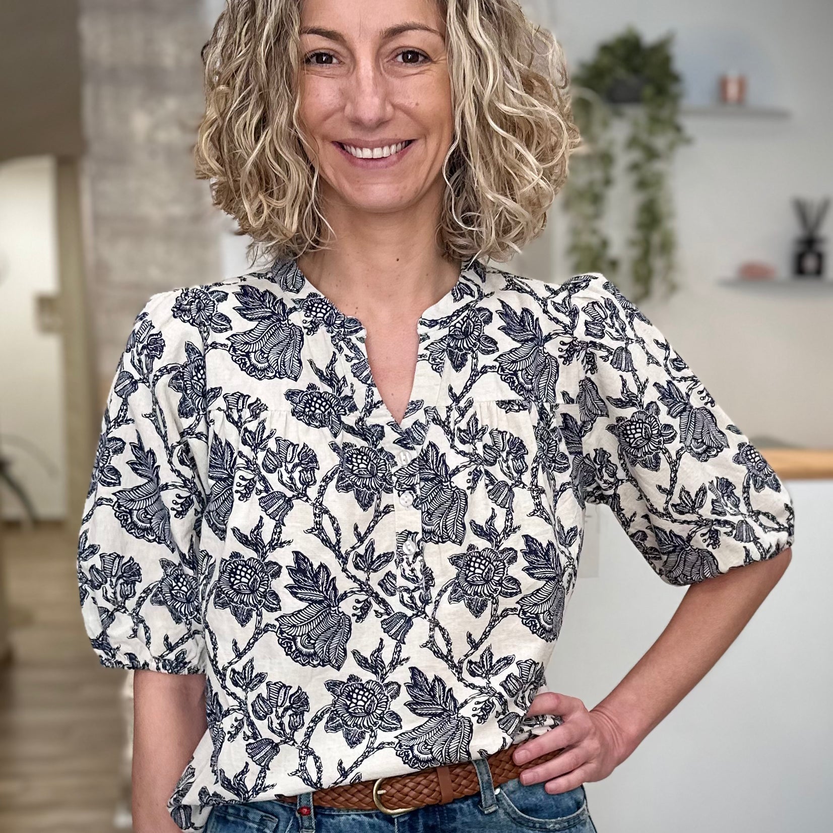 Femme portant une blouse florale écru et bleu marine coupe fluide 