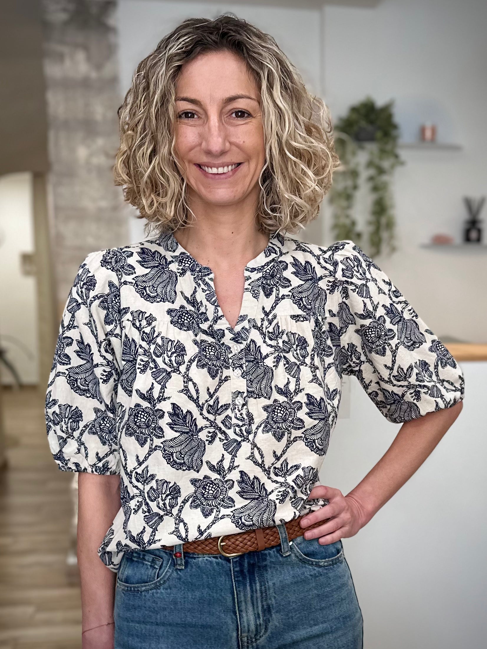 Femme portant une blouse florale écru et bleu marine coupe fluide 