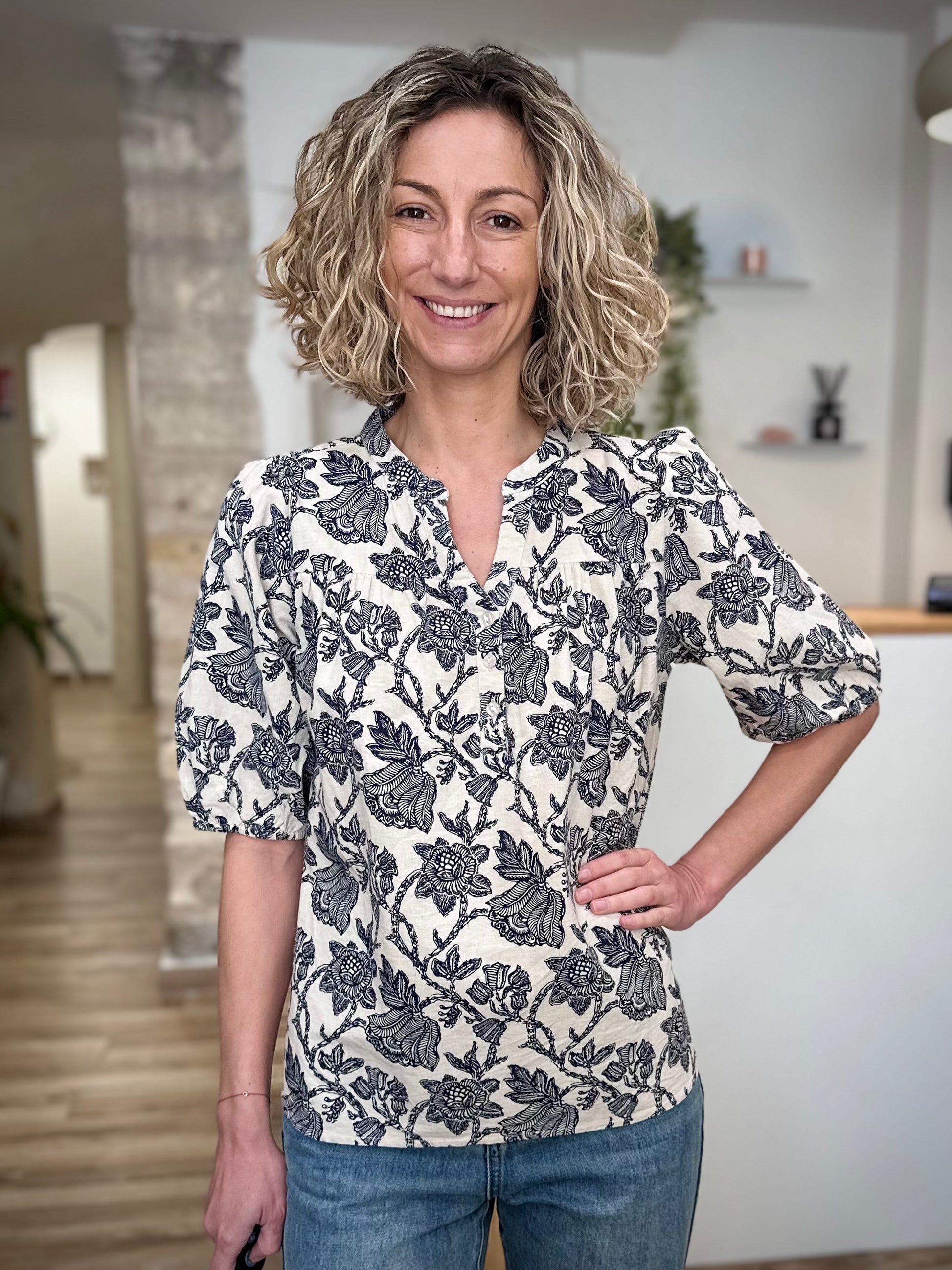 Femme souriante portant blouse imprimée bleu marine 