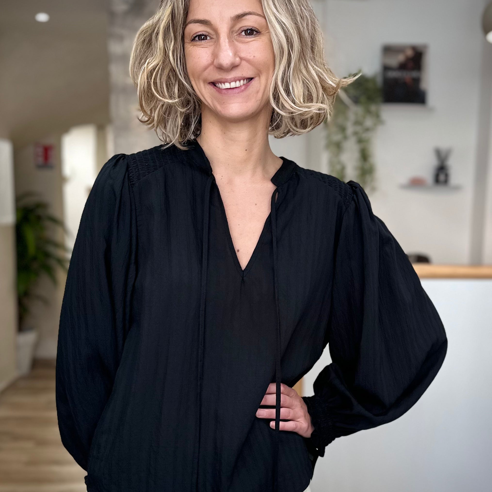 Femme portant une blouse noire fluide à col noué