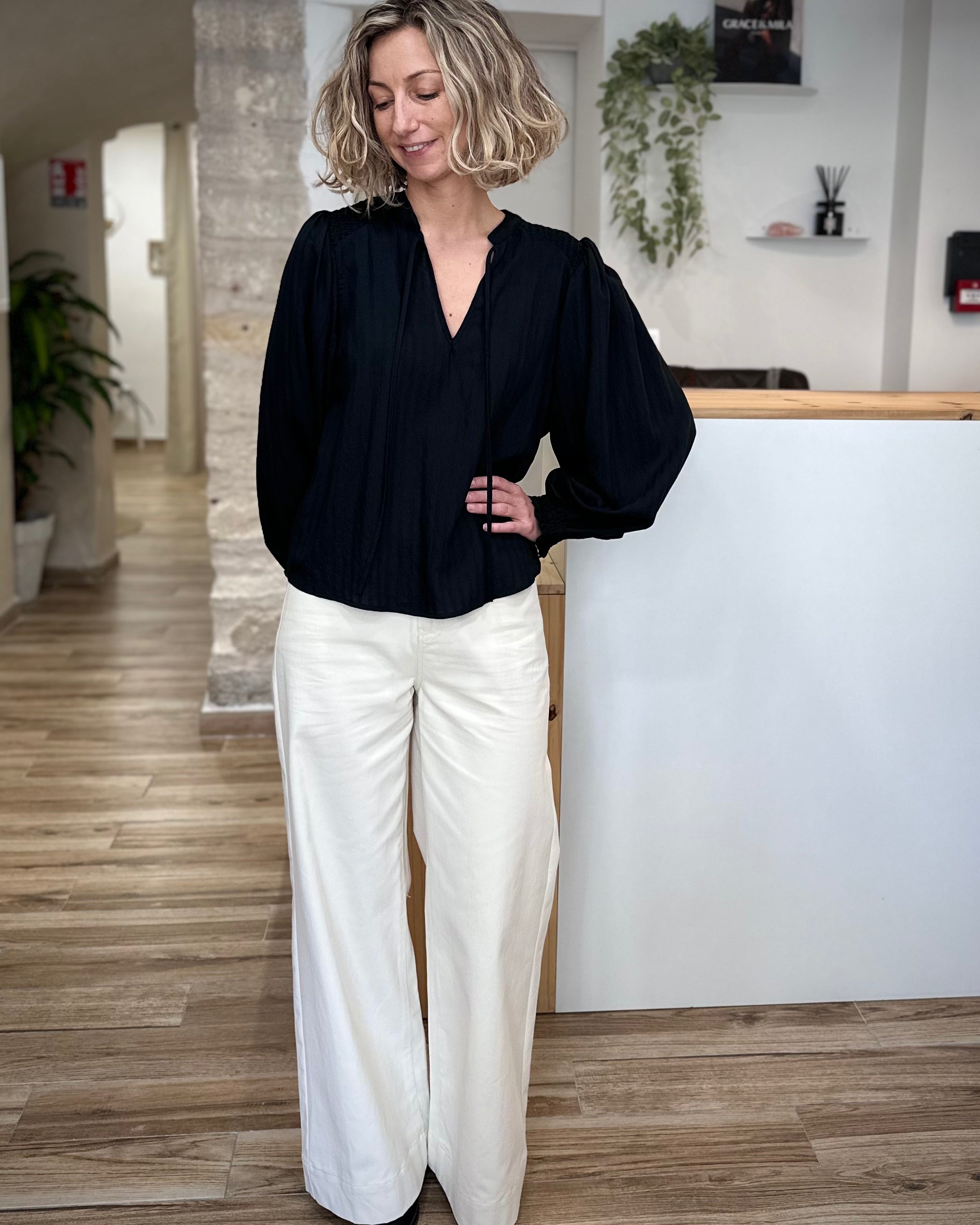 Mannequin en blouse fluide noire et pantalon clair