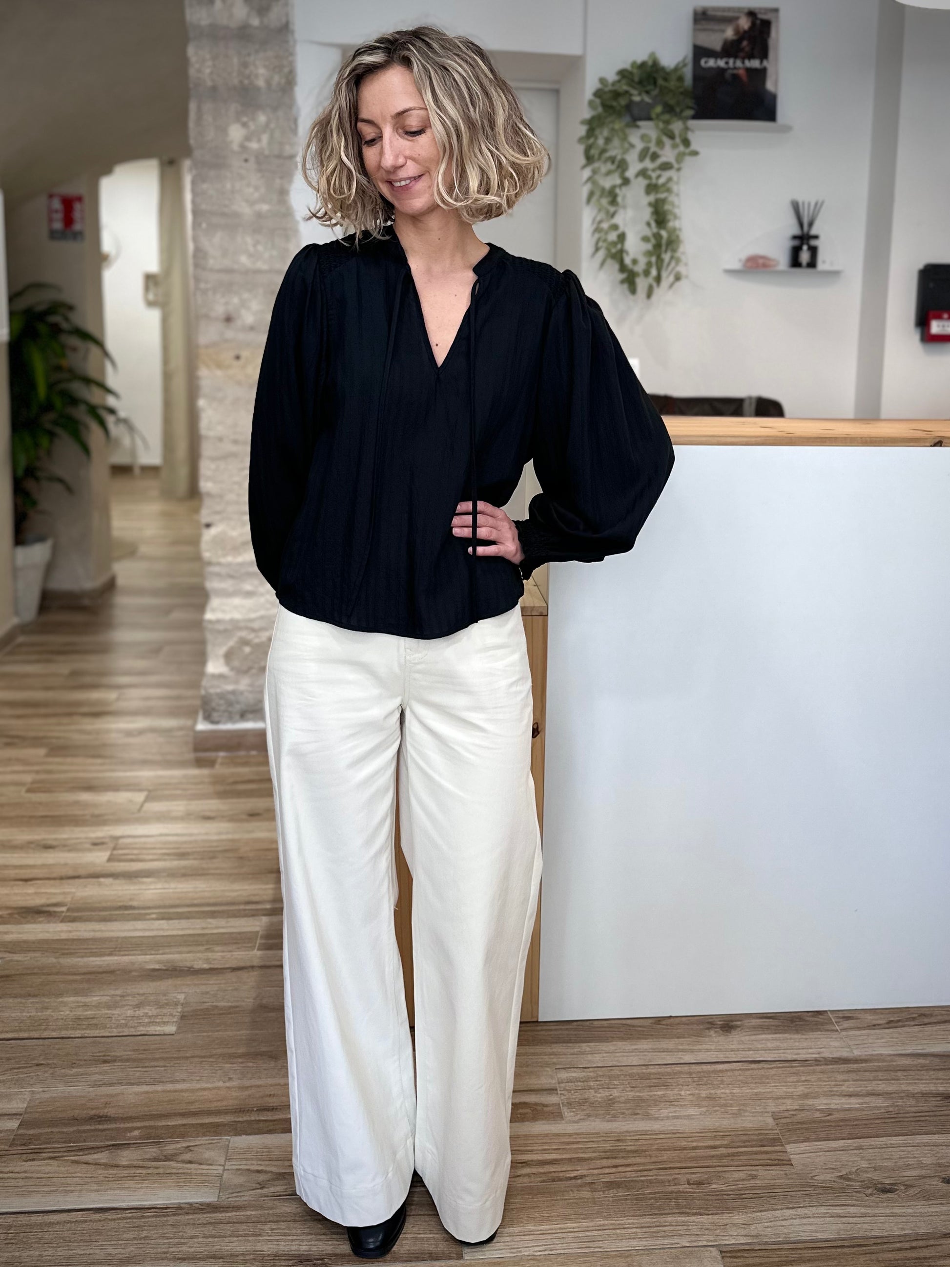 Mannequin en blouse fluide noire et pantalon clair