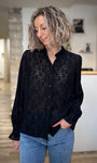 Femme portant une blouse noire en dentelle chic