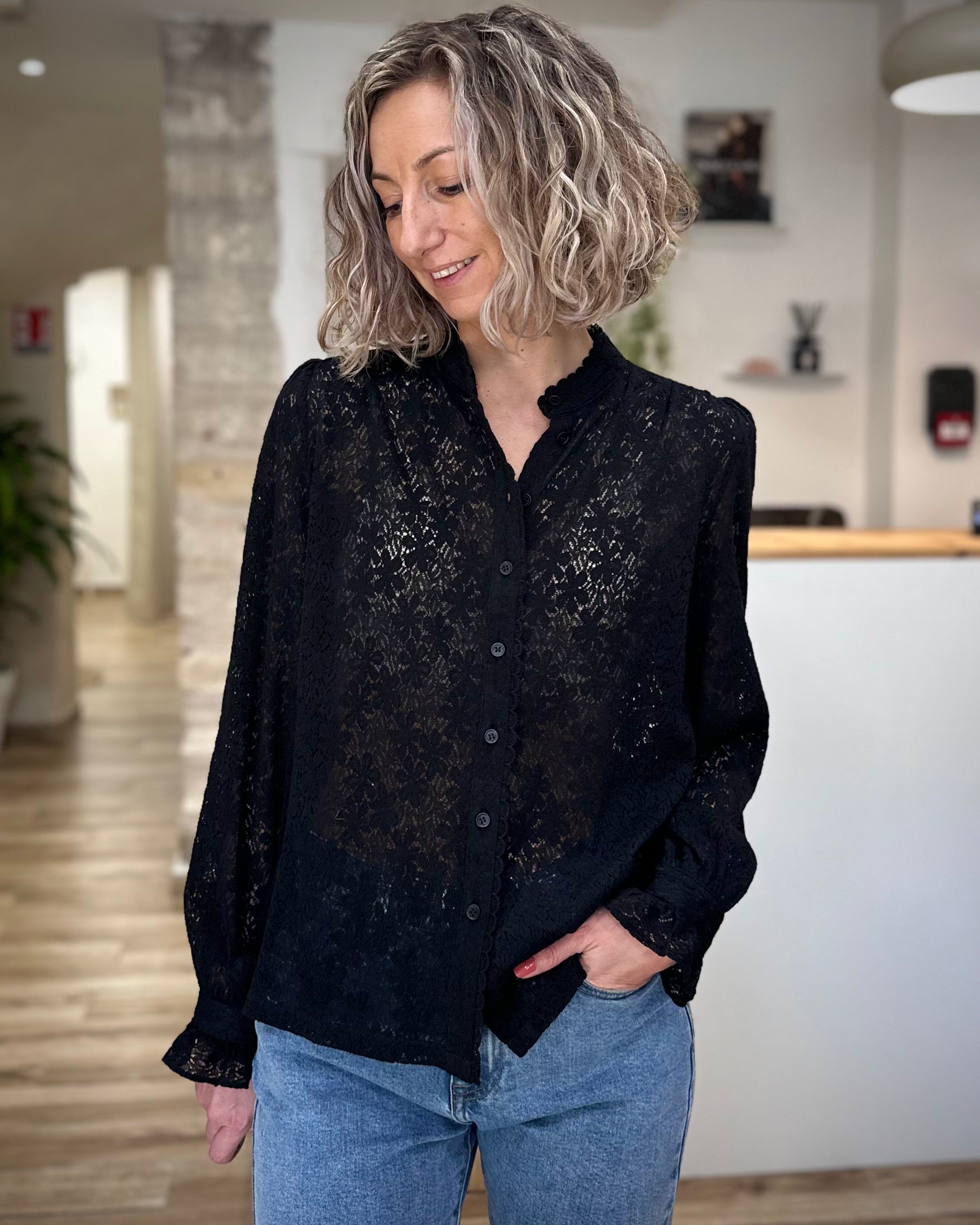 Femme portant une blouse noire en dentelle chic