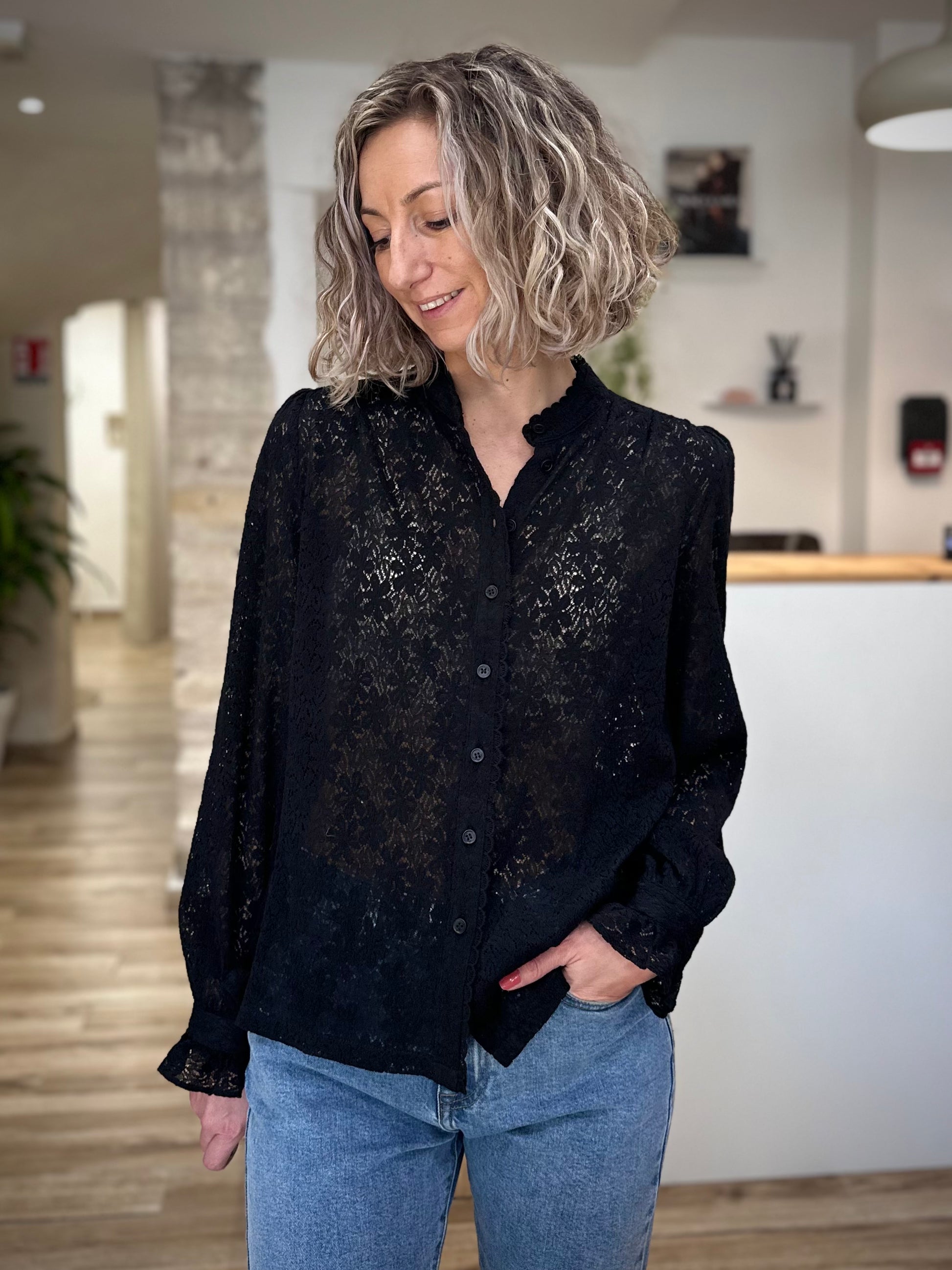 Femme portant une blouse noire en dentelle chic