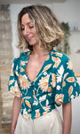 Femme portant une blouse fleurie verte col V 