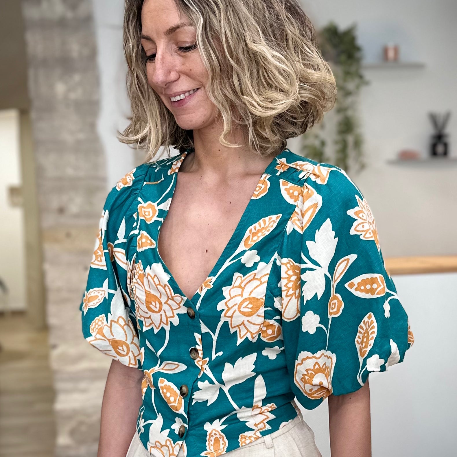 Femme portant une blouse fleurie verte col V 