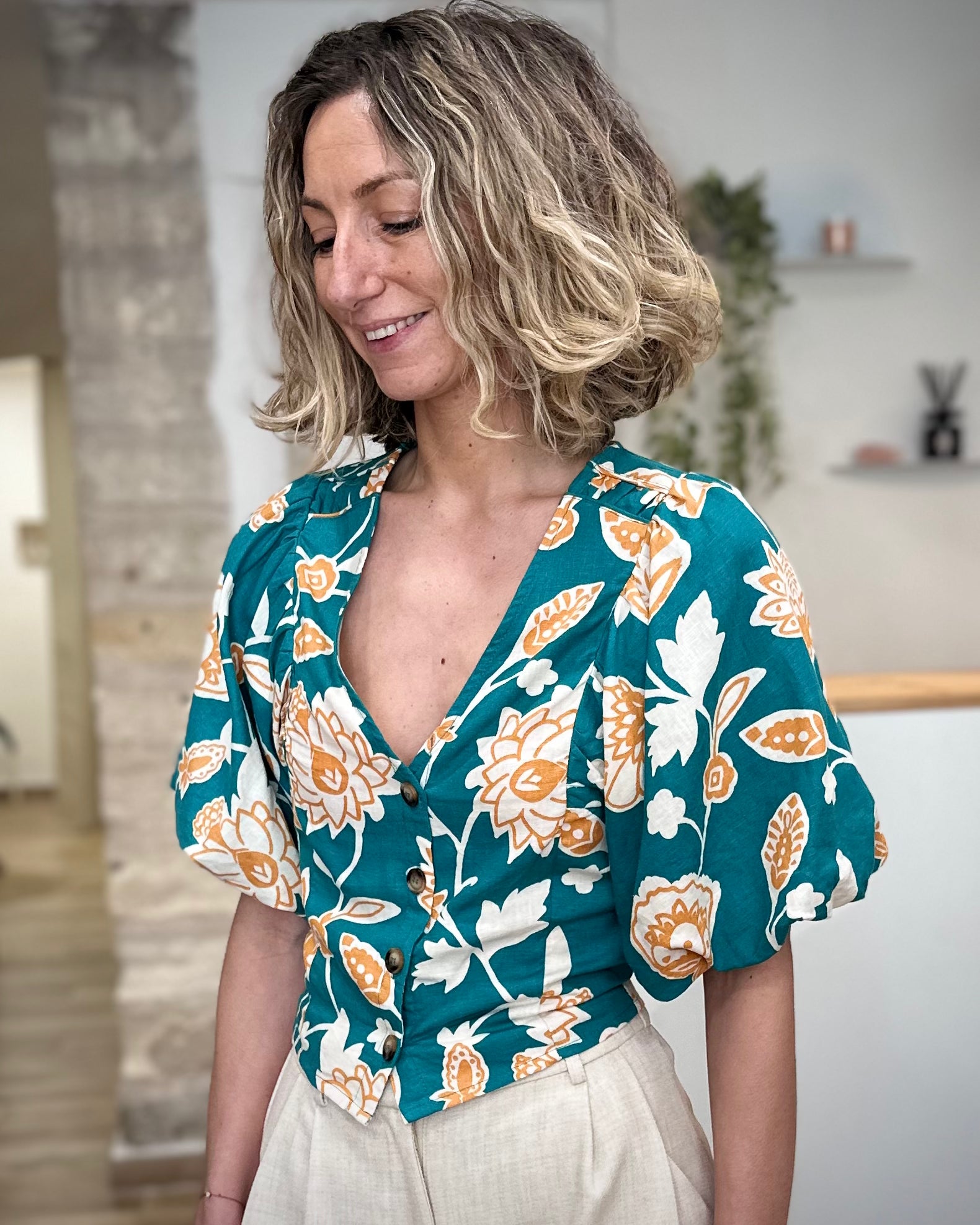 Femme portant une blouse fleurie verte col V 