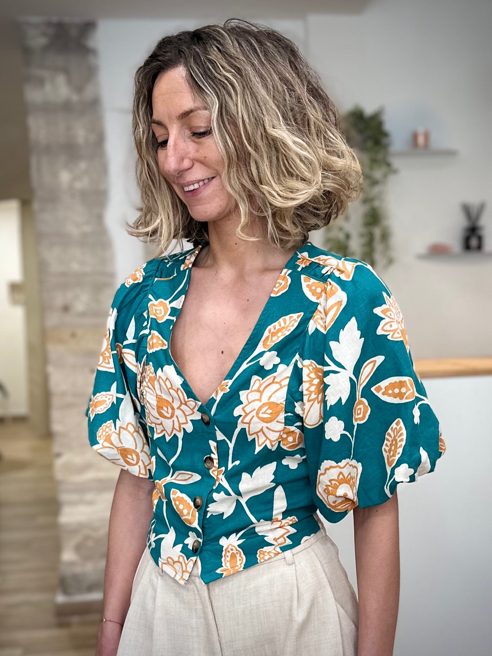 Femme portant une blouse fleurie verte col V 