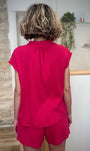 Femme de dos portant une blouse aérienne en gaze de coton fuchsia
