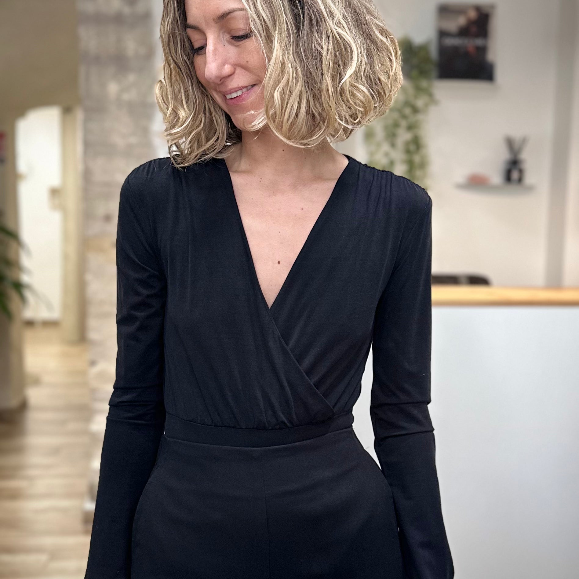 Femme portant un body noir cache-cœur élégant