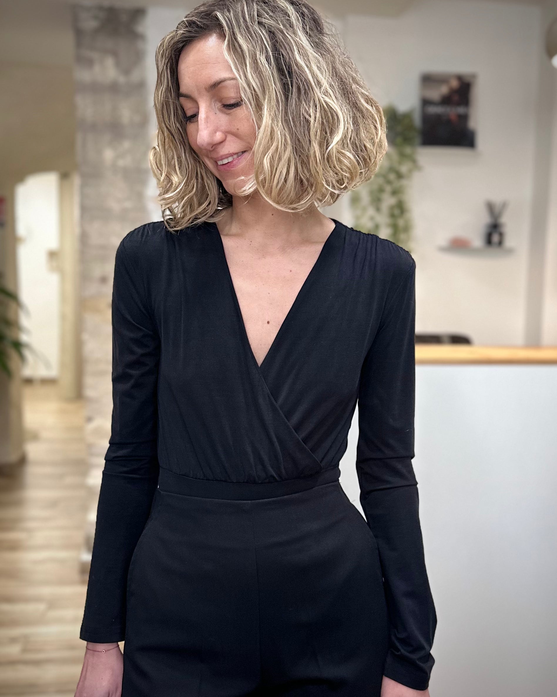 Femme portant un body noir cache-cœur élégant