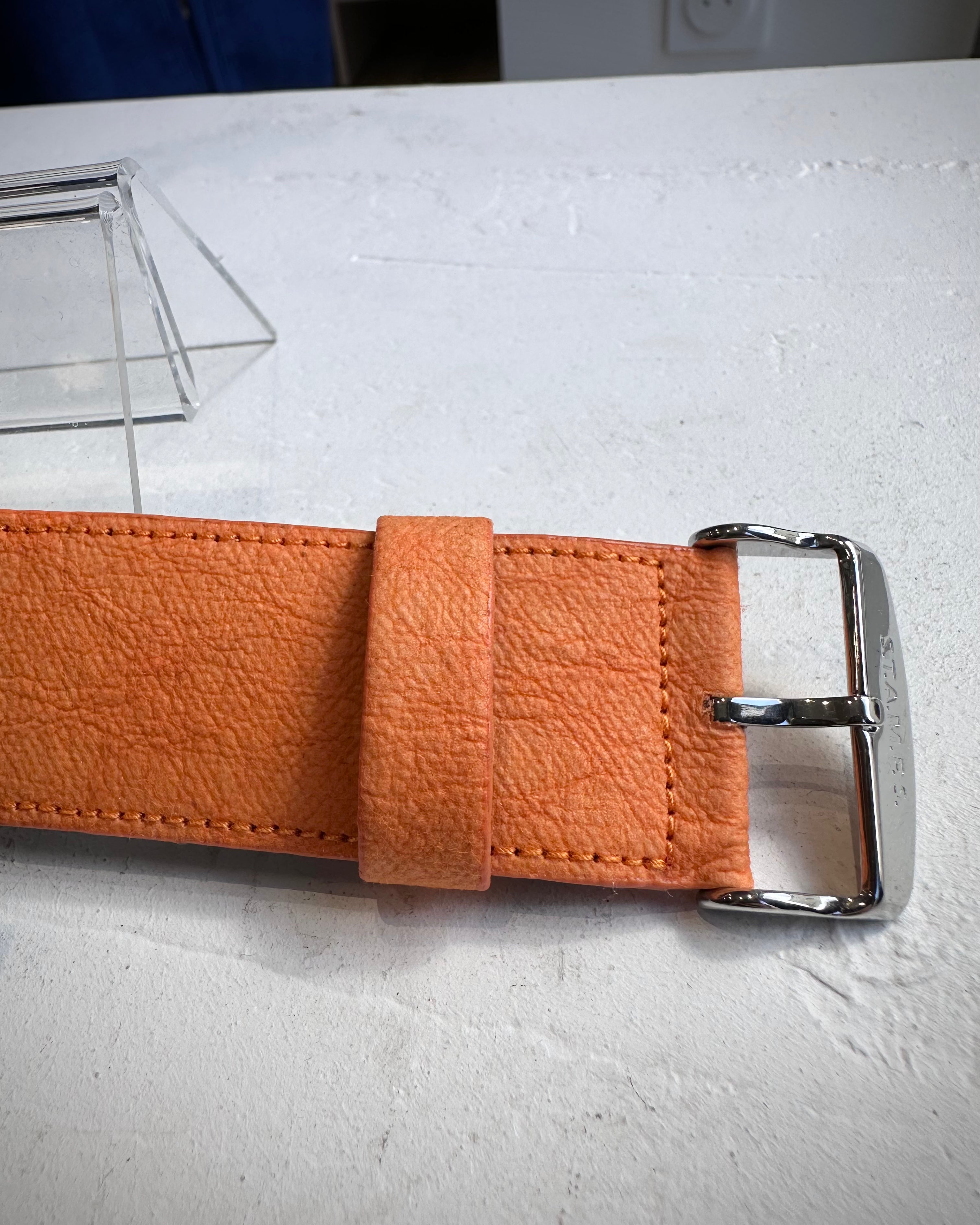 Gros plan sur la texture STAMPSTexx du bracelet orange
