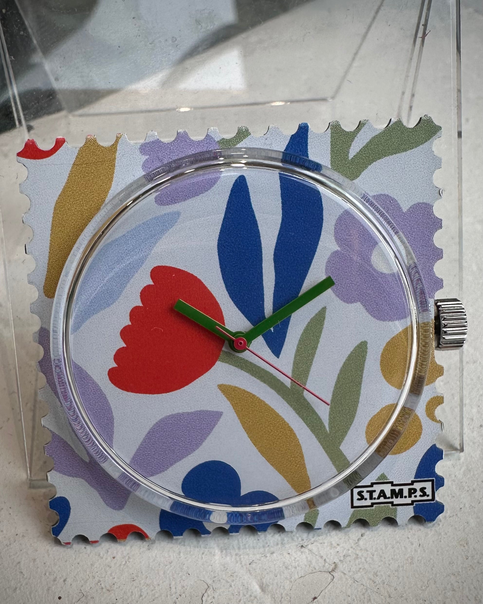 Gros plan cadran STAMPS fleurs avec aiguilles vertes 