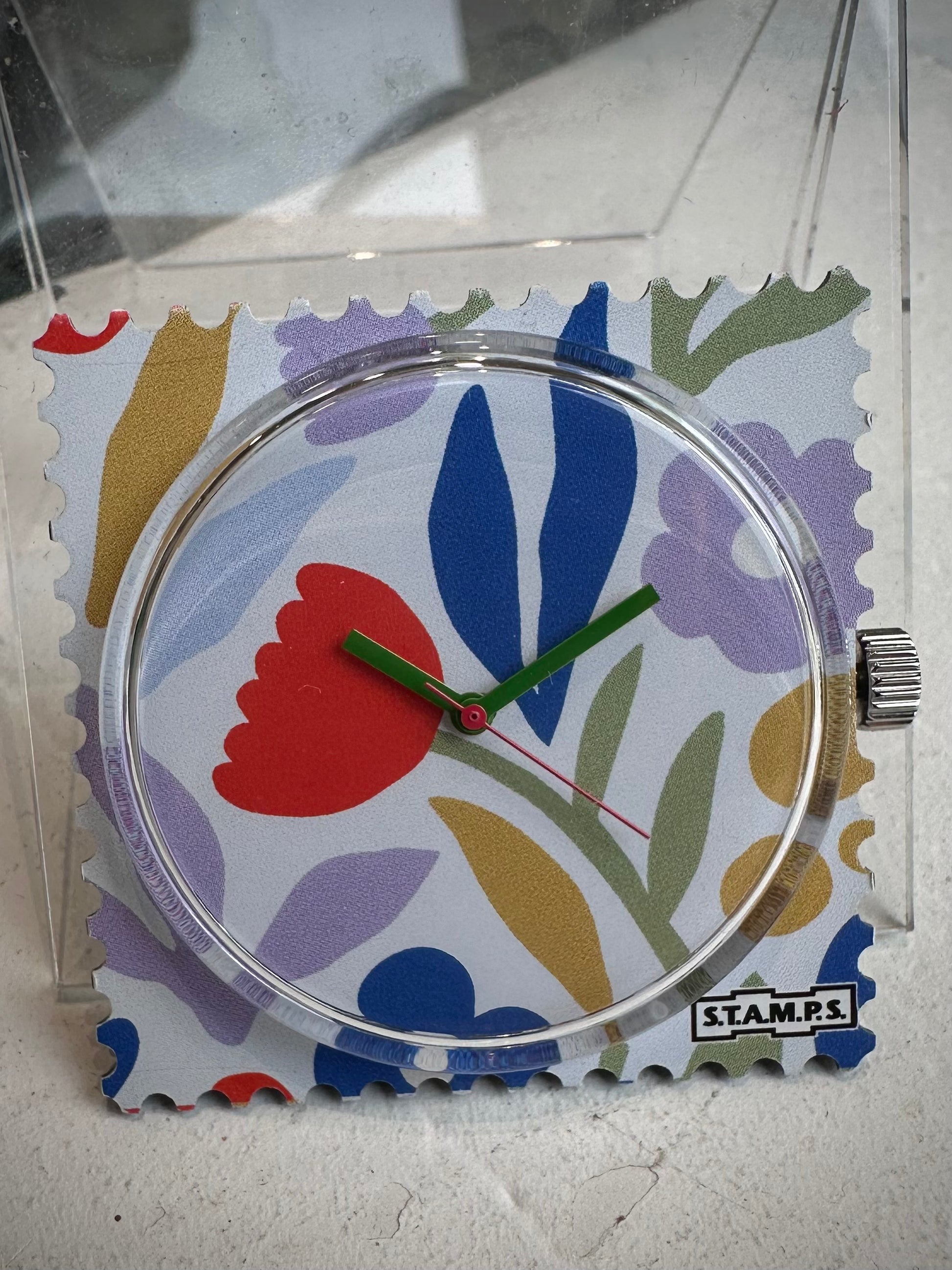 Gros plan cadran STAMPS fleurs avec aiguilles vertes 