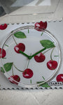 Gros plan cadran STAMPS cerises avec aiguilles vertes 