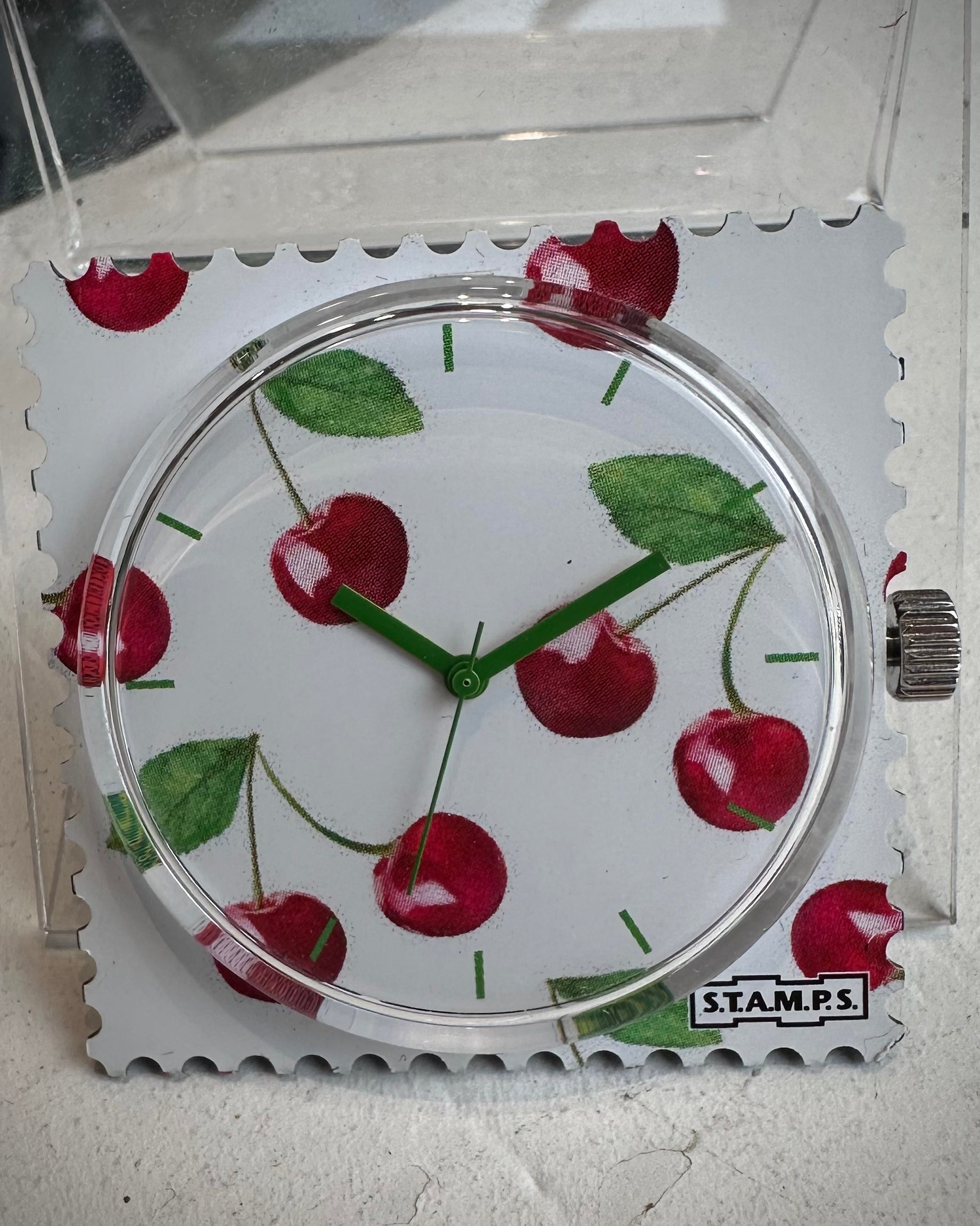 Gros plan cadran STAMPS cerises avec aiguilles vertes 