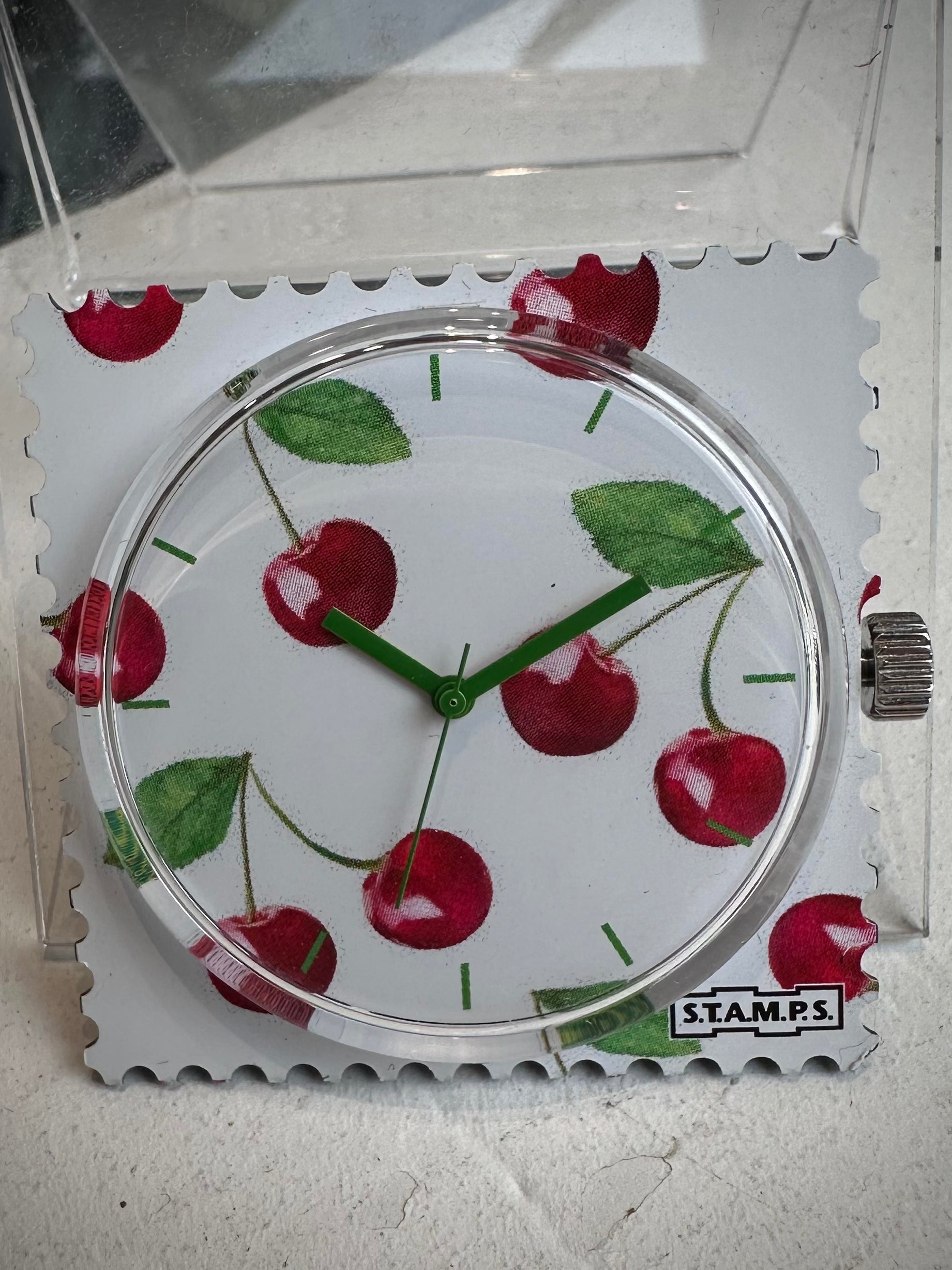 Gros plan cadran STAMPS cerises avec aiguilles vertes 