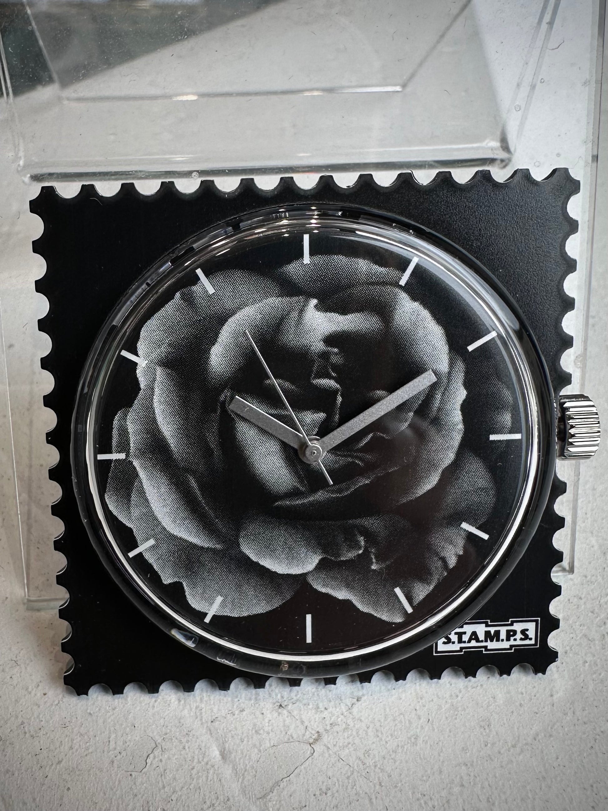 Gros plan cadran STAMPS rose avec aiguilles argentées 