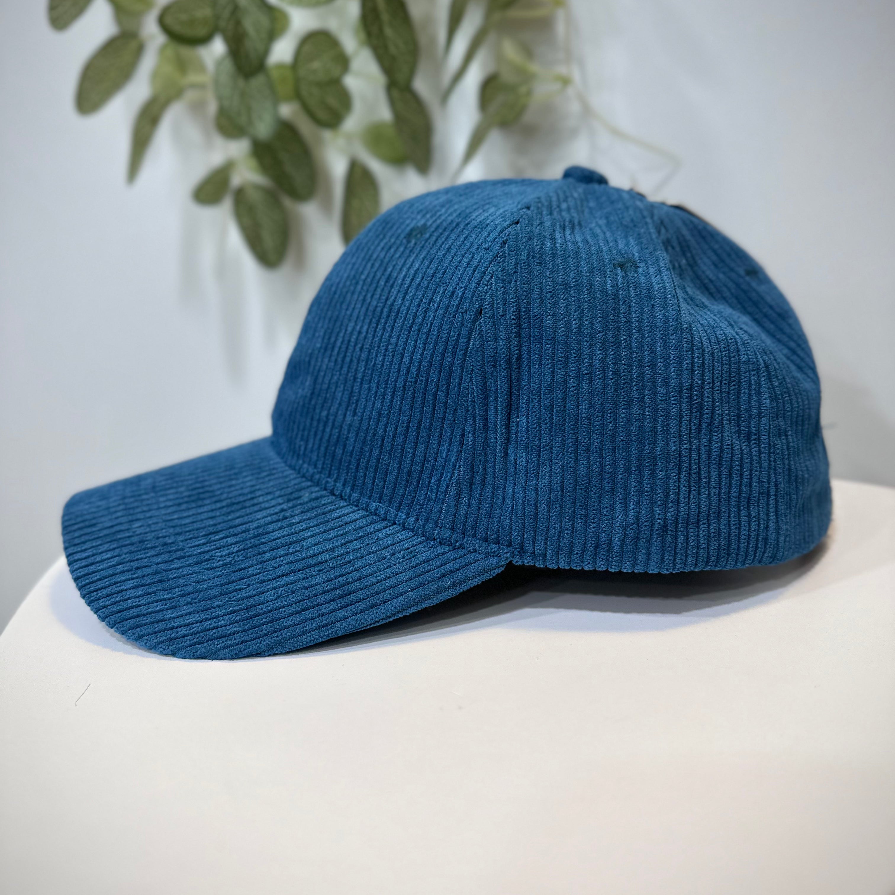 Casquette velours bleu mat posée sur une table