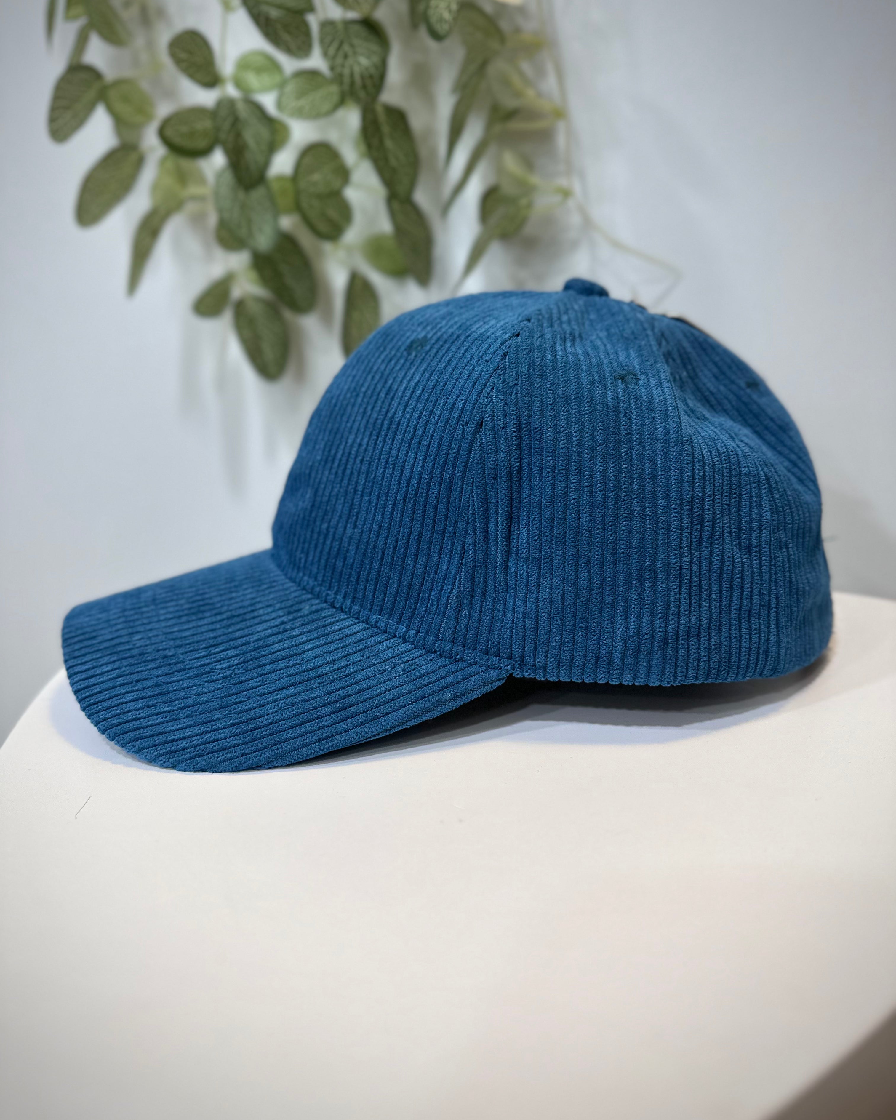 Casquette velours bleu mat posée sur une table