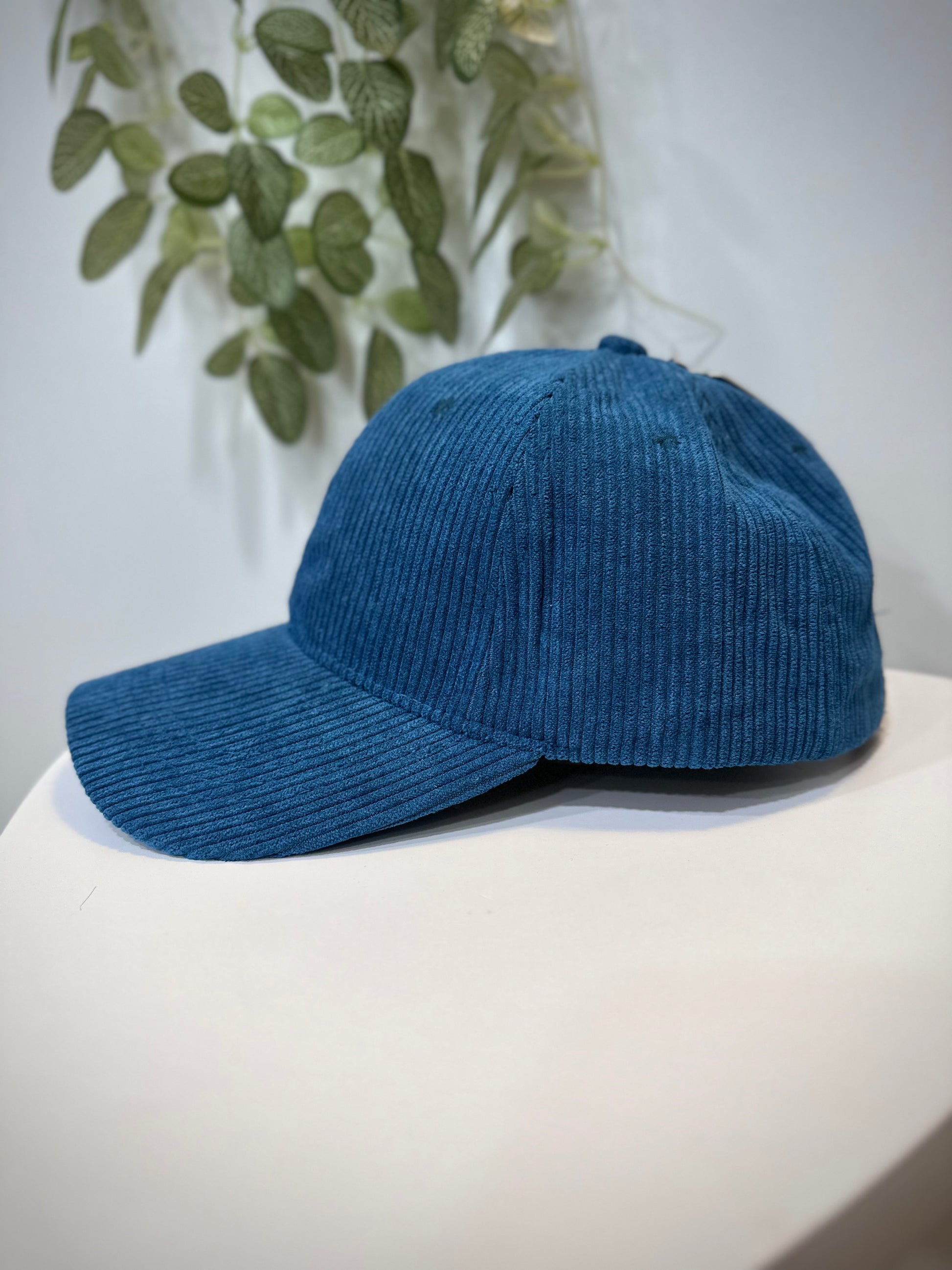 Casquette velours bleu mat posée sur une table