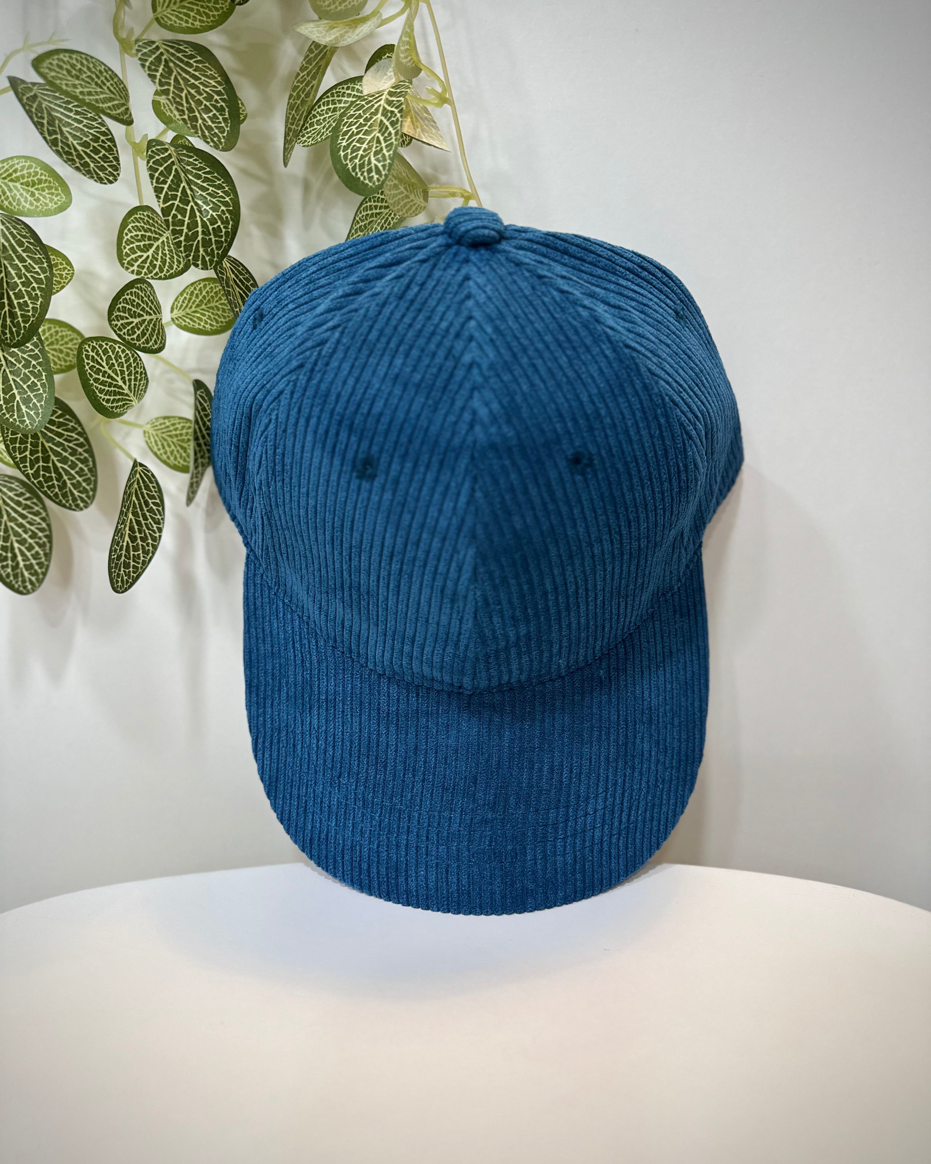 Casquette velours bleu mat posée sur une table