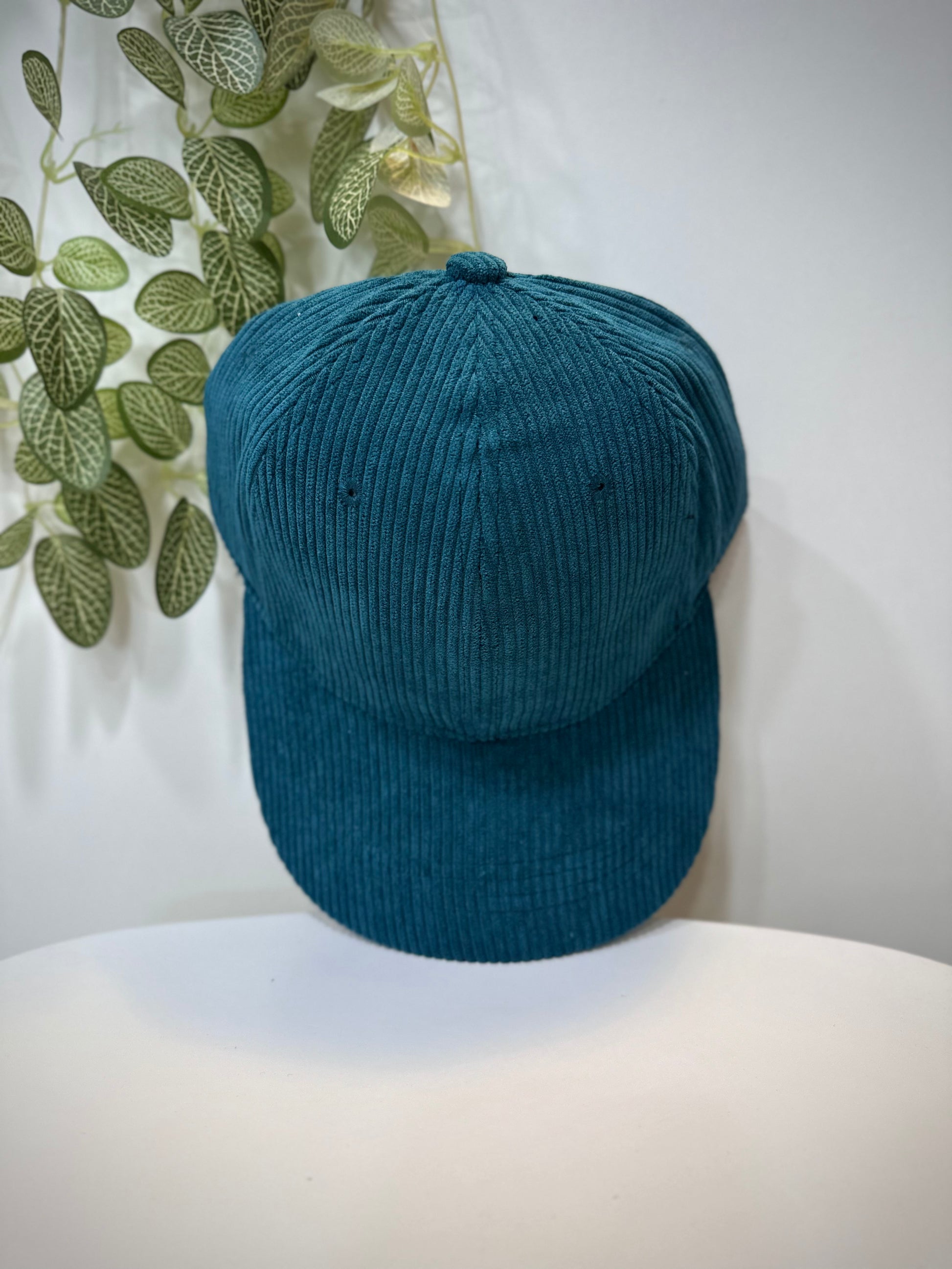 Casquette velours bleu canard posée sur une table 