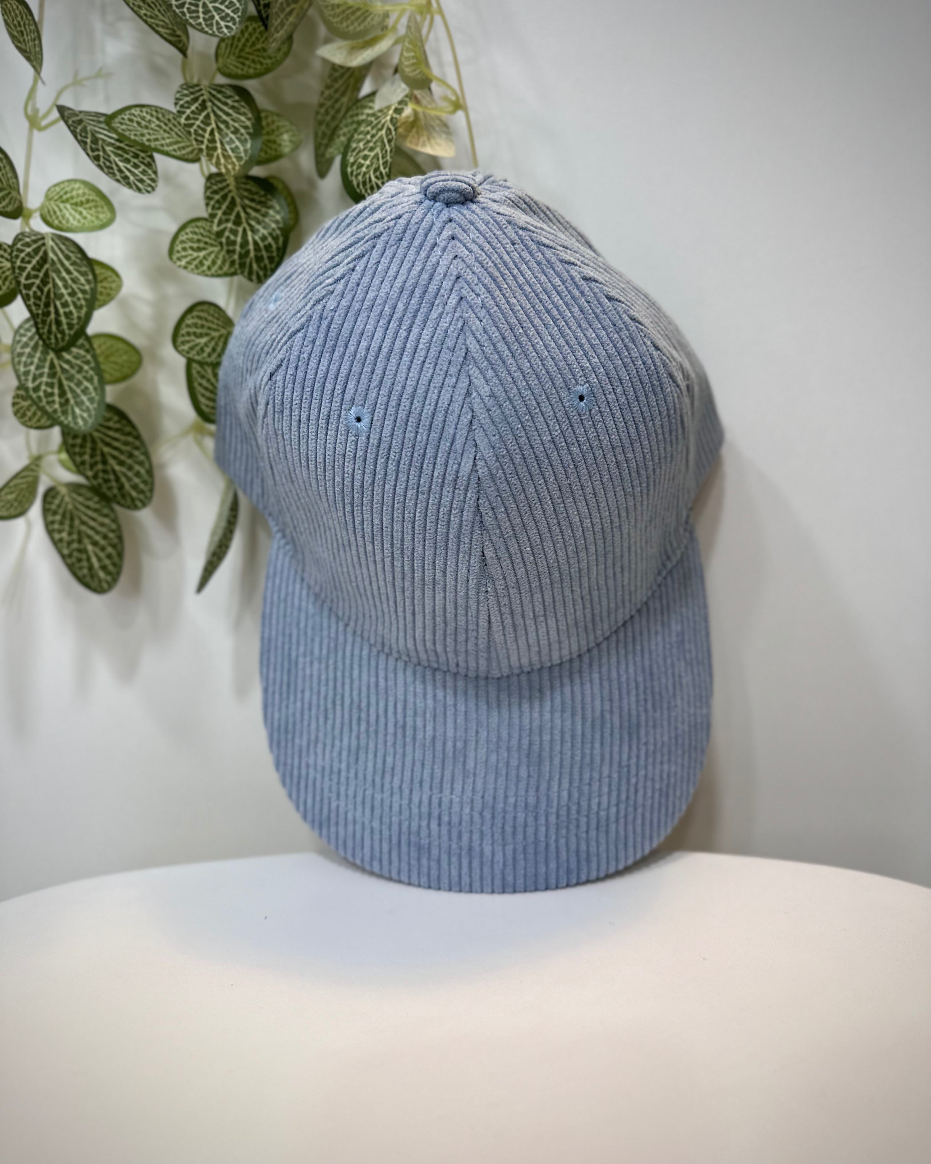 Casquette velours bleu ciel posée sur une table