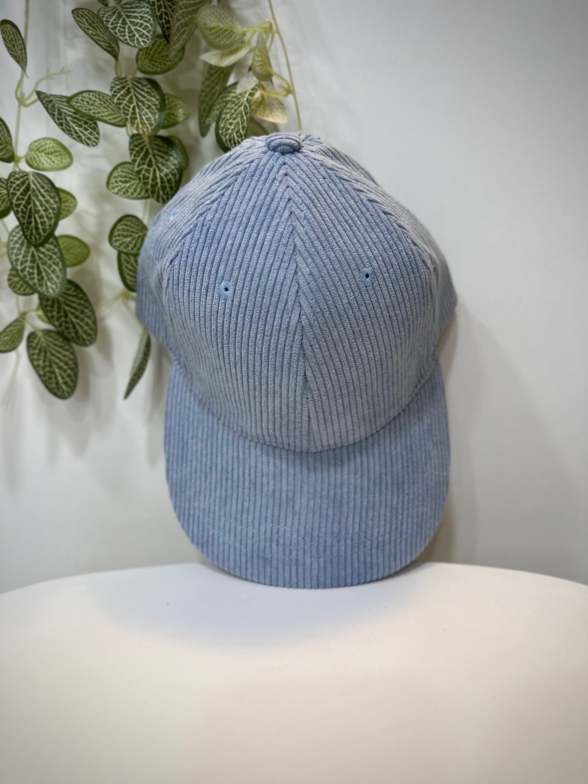 Casquette velours bleu ciel posée sur une table