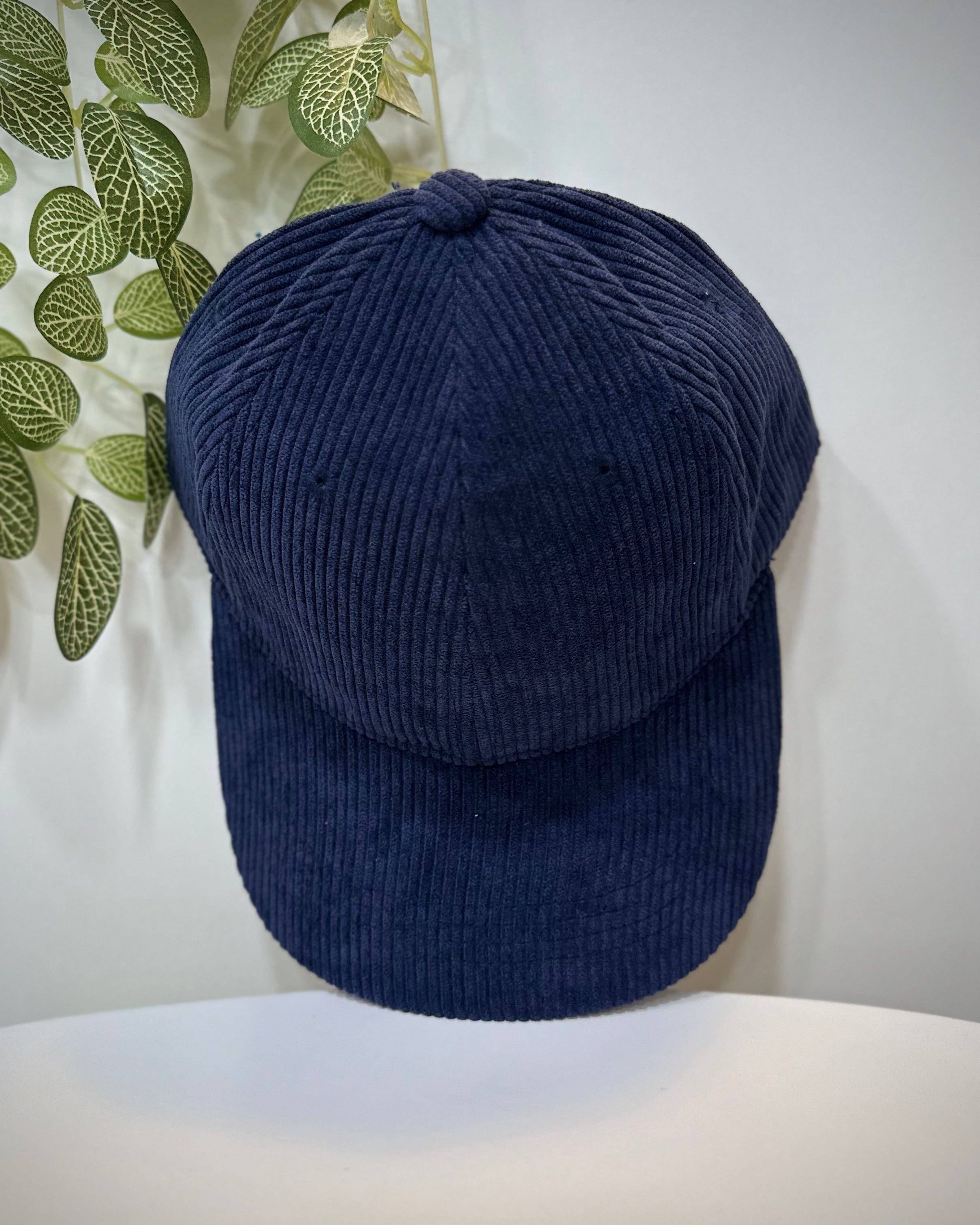 Casquette velours bleu marine posée sur une table
