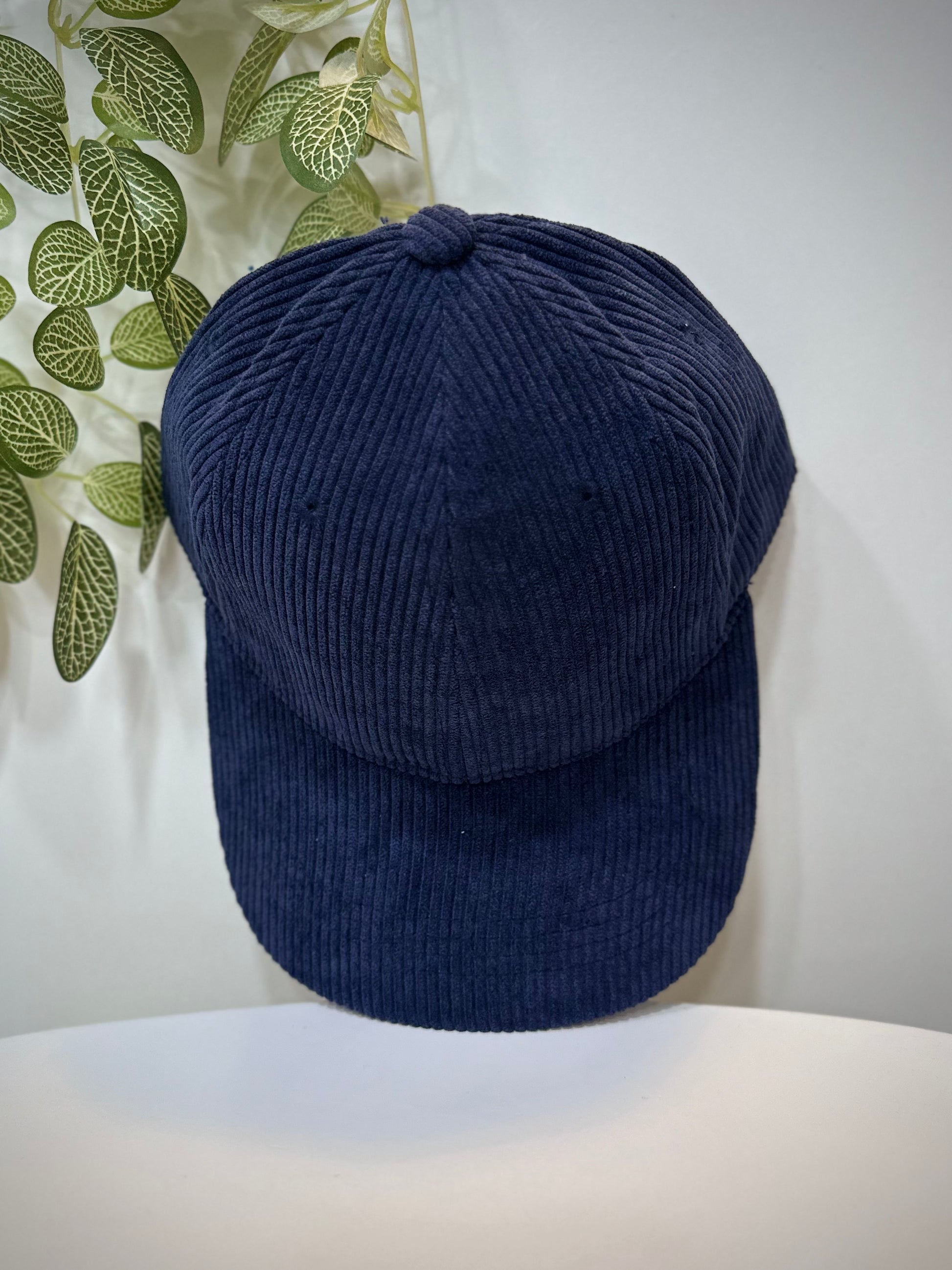 Casquette velours bleu marine posée sur une table