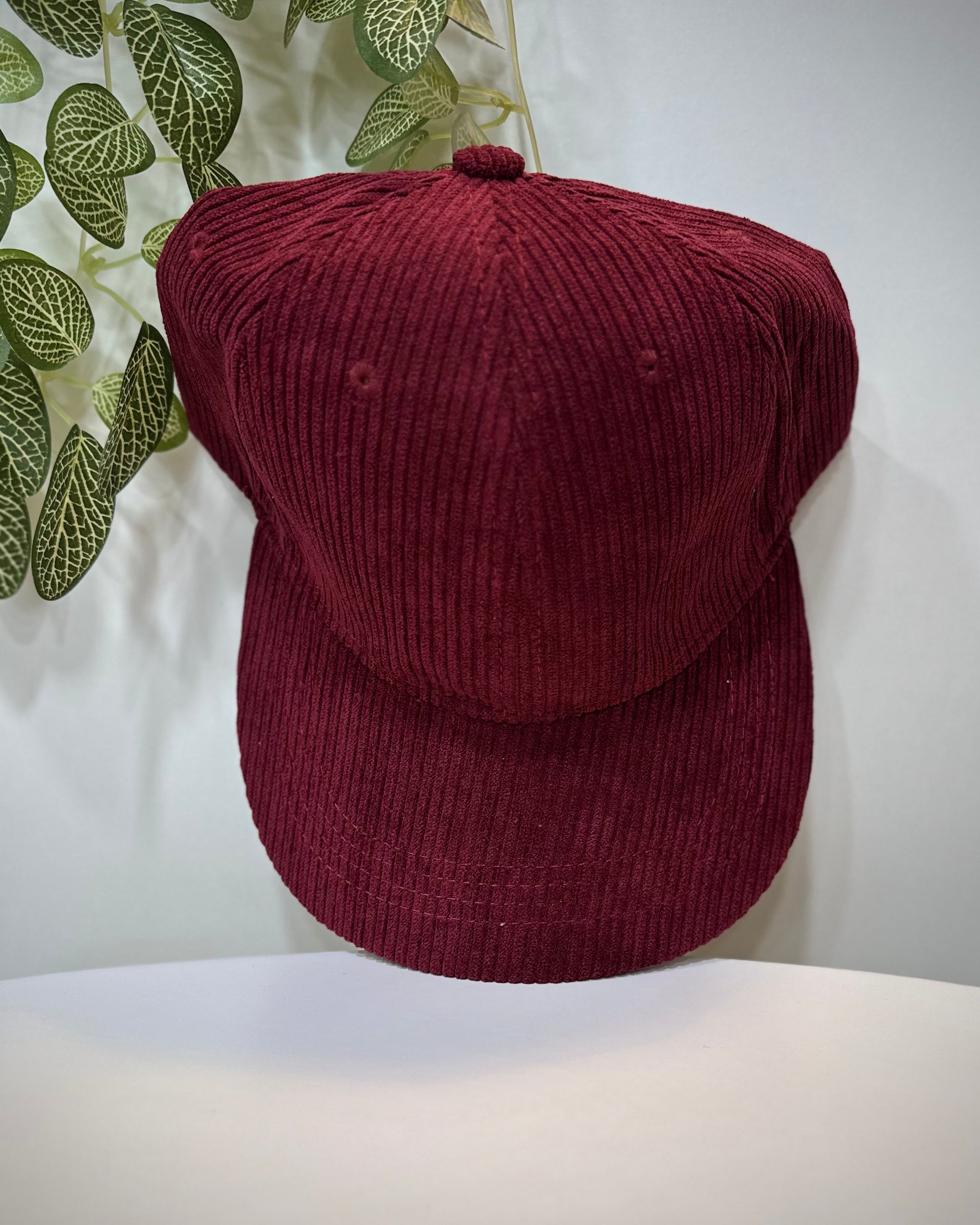Casquette velours bordeaux posée sur une table