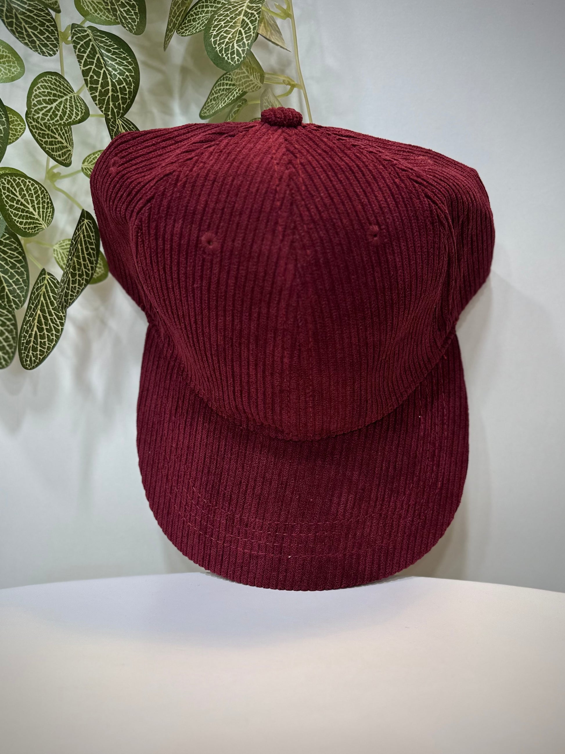 Casquette velours bordeaux posée sur une table