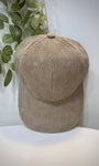 Casquette velours taupe posée sur une table