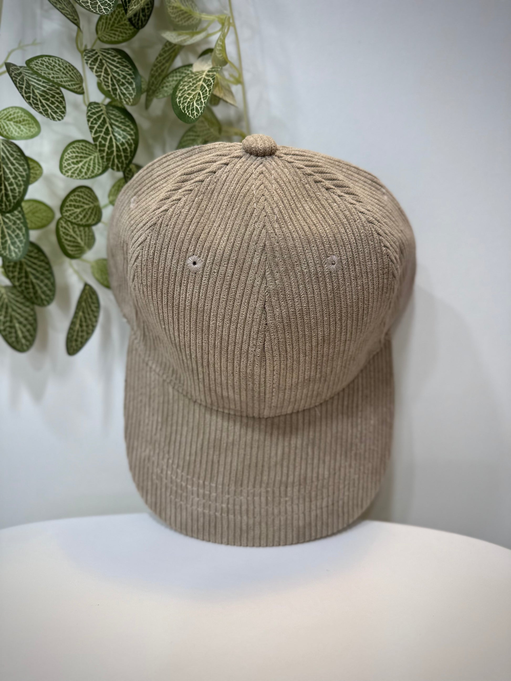 Casquette velours taupe posée sur une table