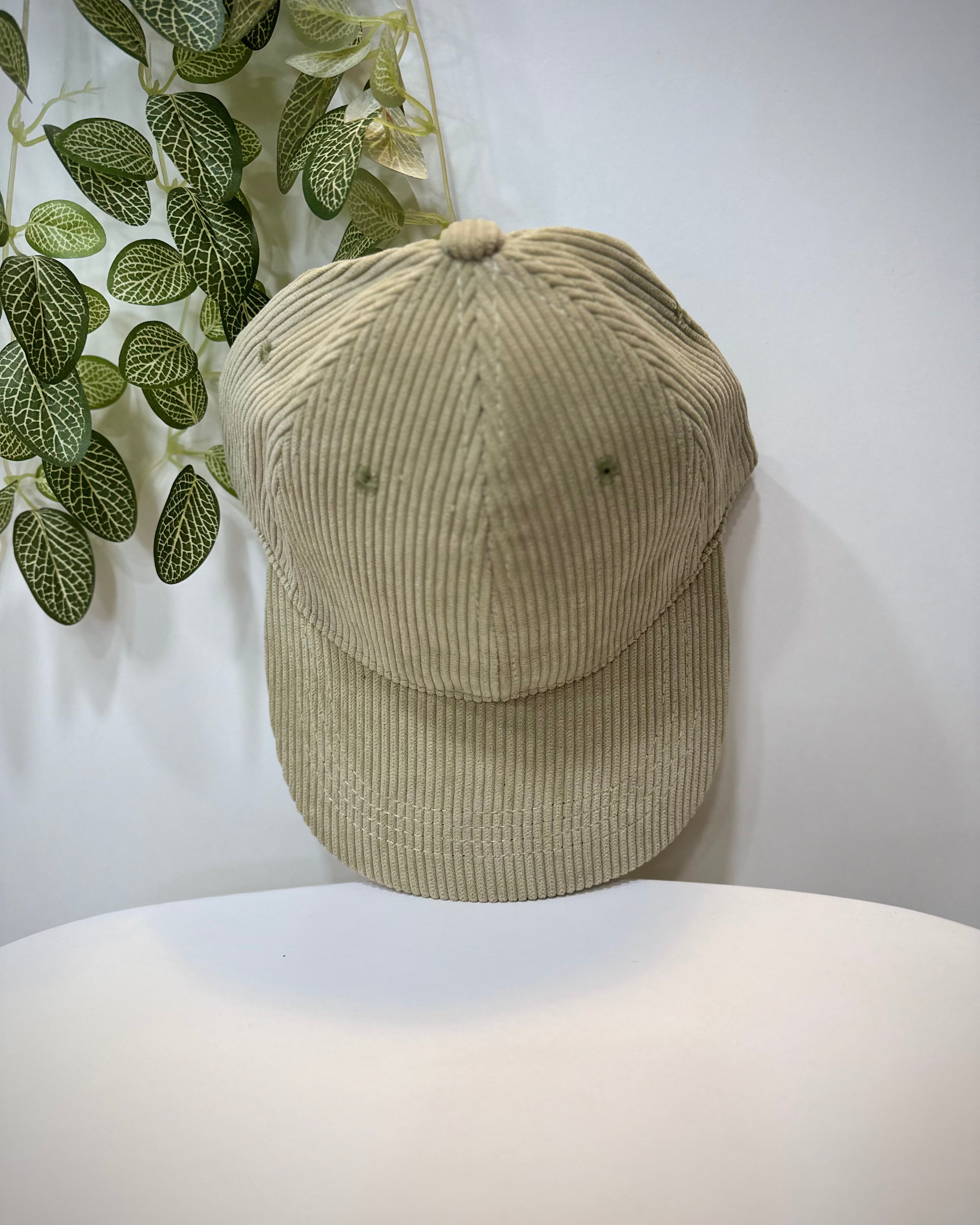 Casquette velours vert clair posée sur une table